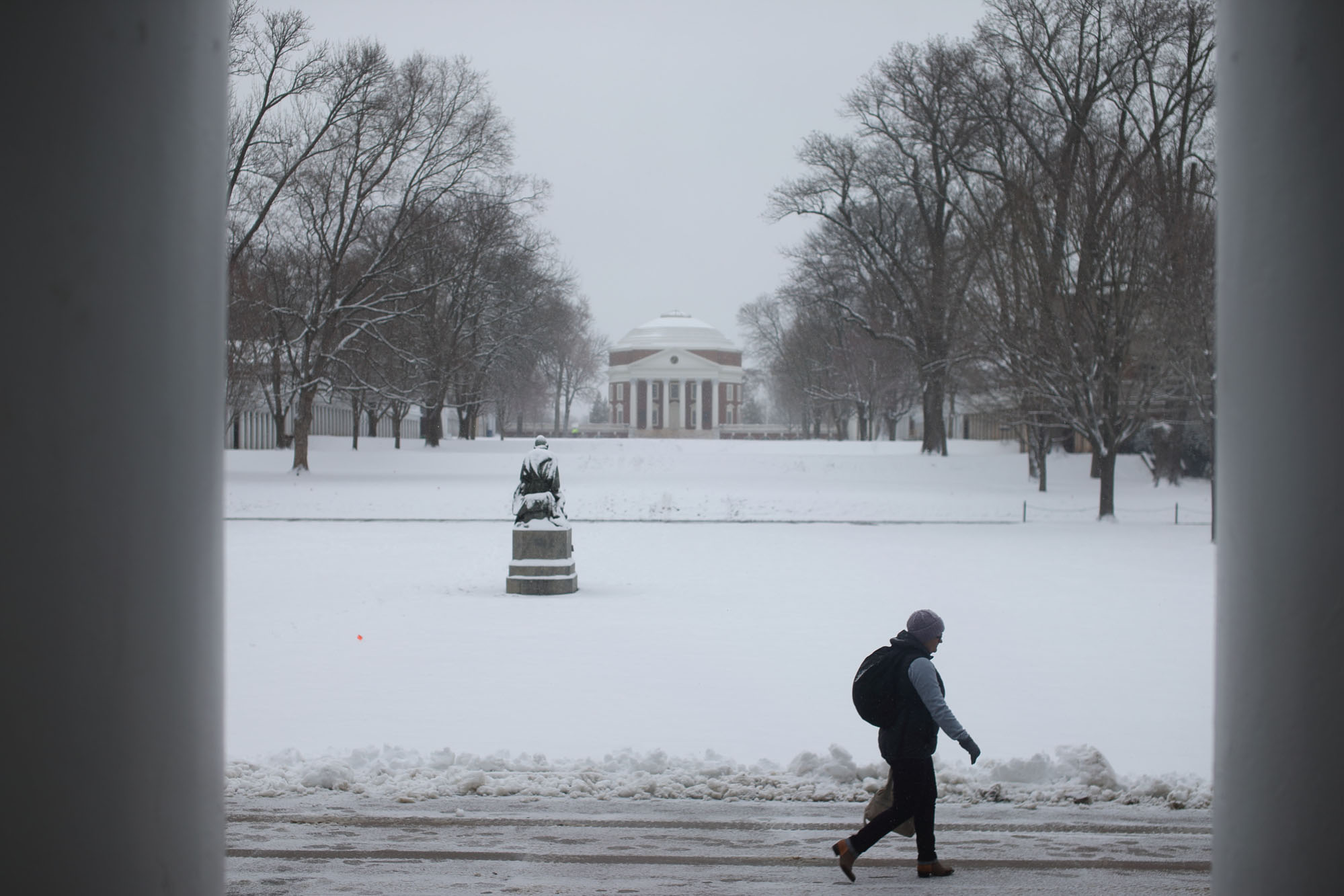 Student walking on a snowy lawn