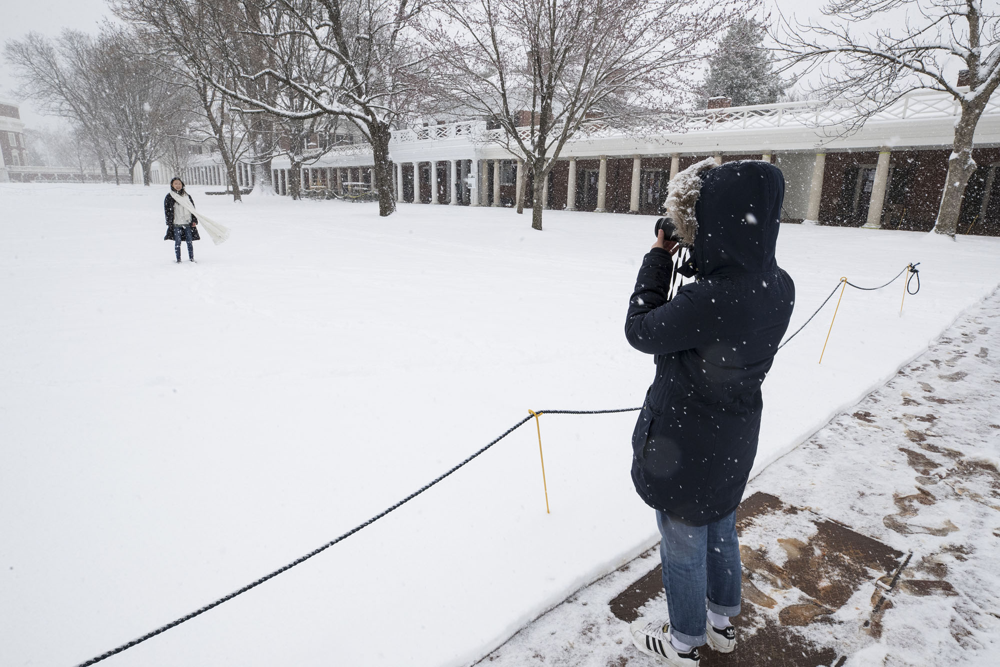 Student taking a picture on Grounds  in the snow