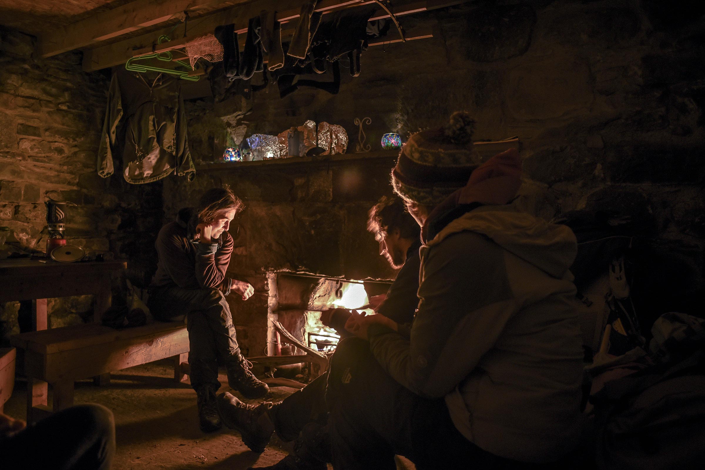 People in a tone building next to a fire place