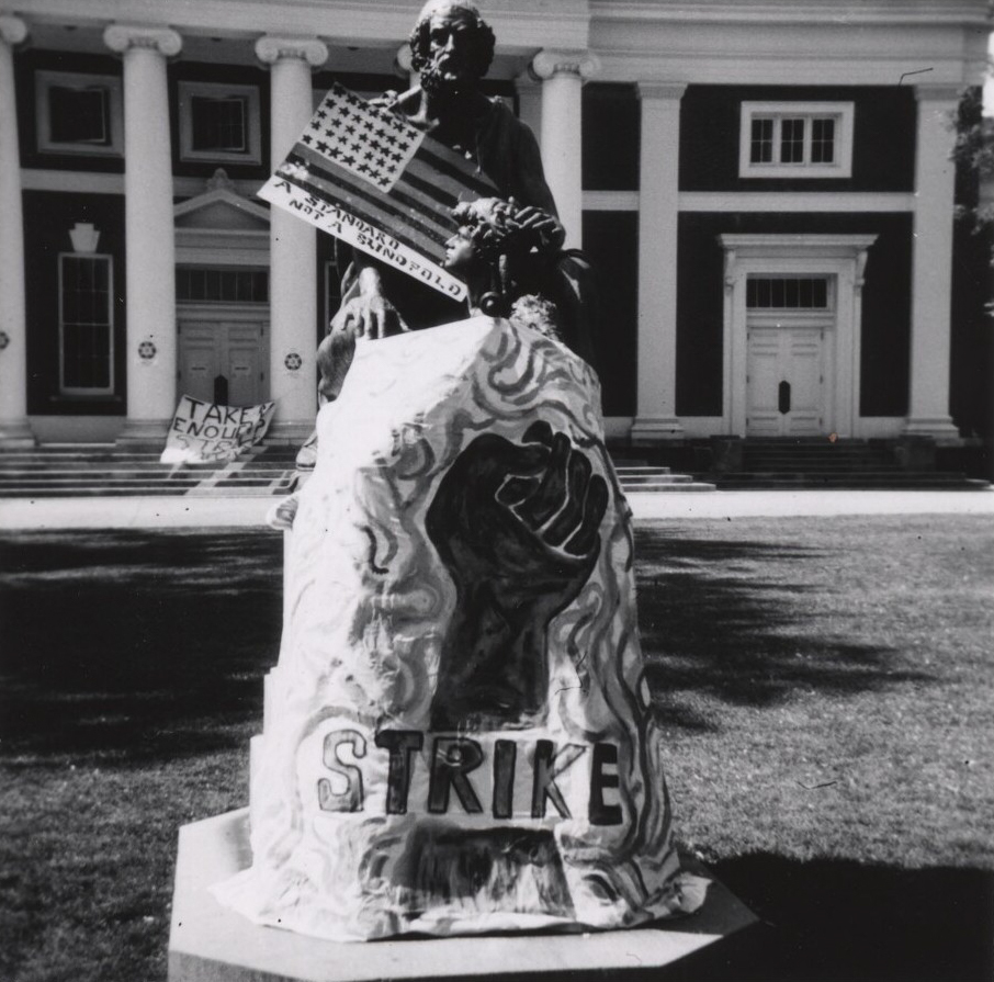 Black and white image of strike signage that was added to the Homer statue on the Lawn 