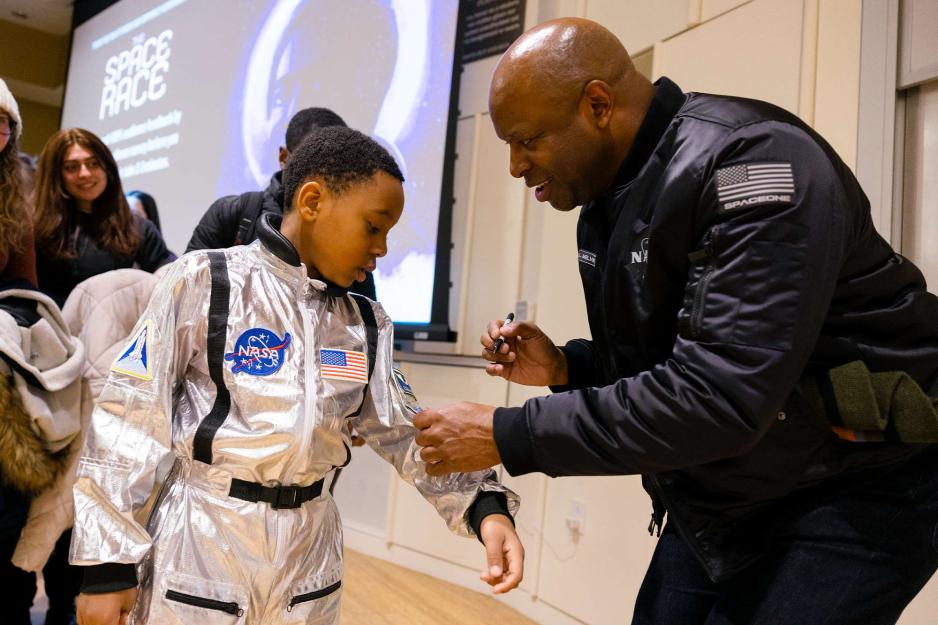Leland Melvin signs kid's space suit
