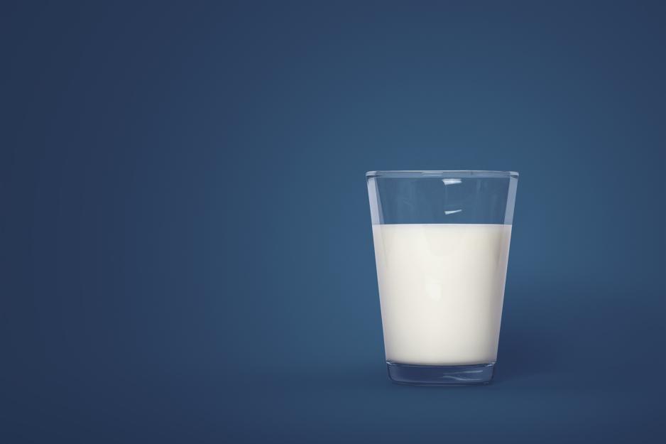 A glass of milk alone on a blue background