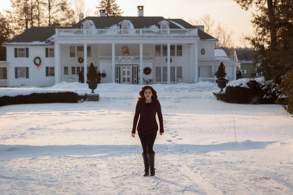 Jen Lilley walking across the snowy ground away from a big house