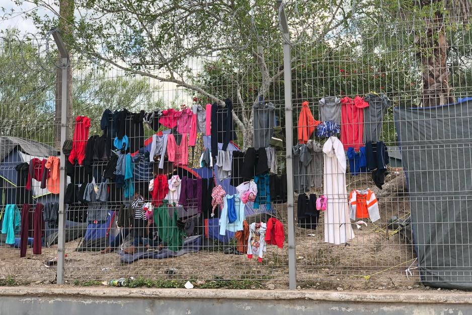 Clothing hanging on a tall metal fence