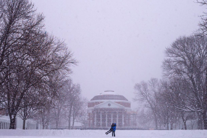 The Rotunda in the snow with two people playing on the lawn
