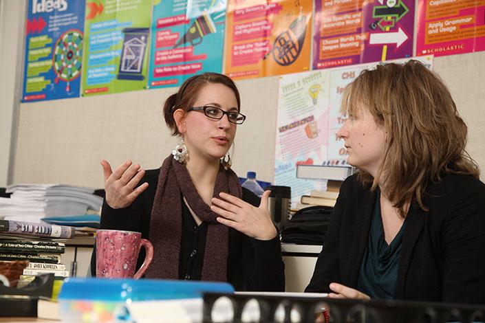 A teacher education student engages in discussion with a veteran teacher. Curry