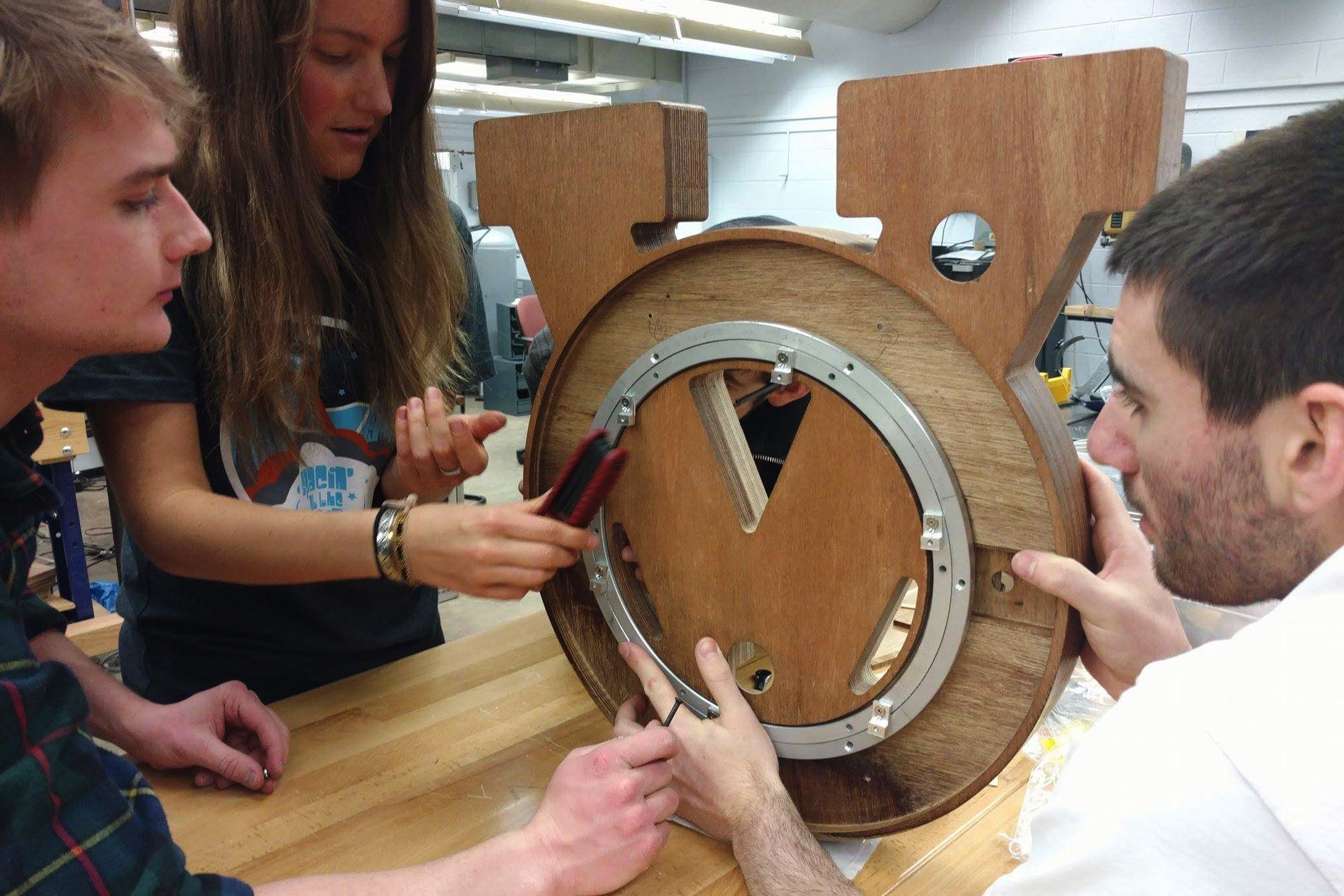 Three students building a clock