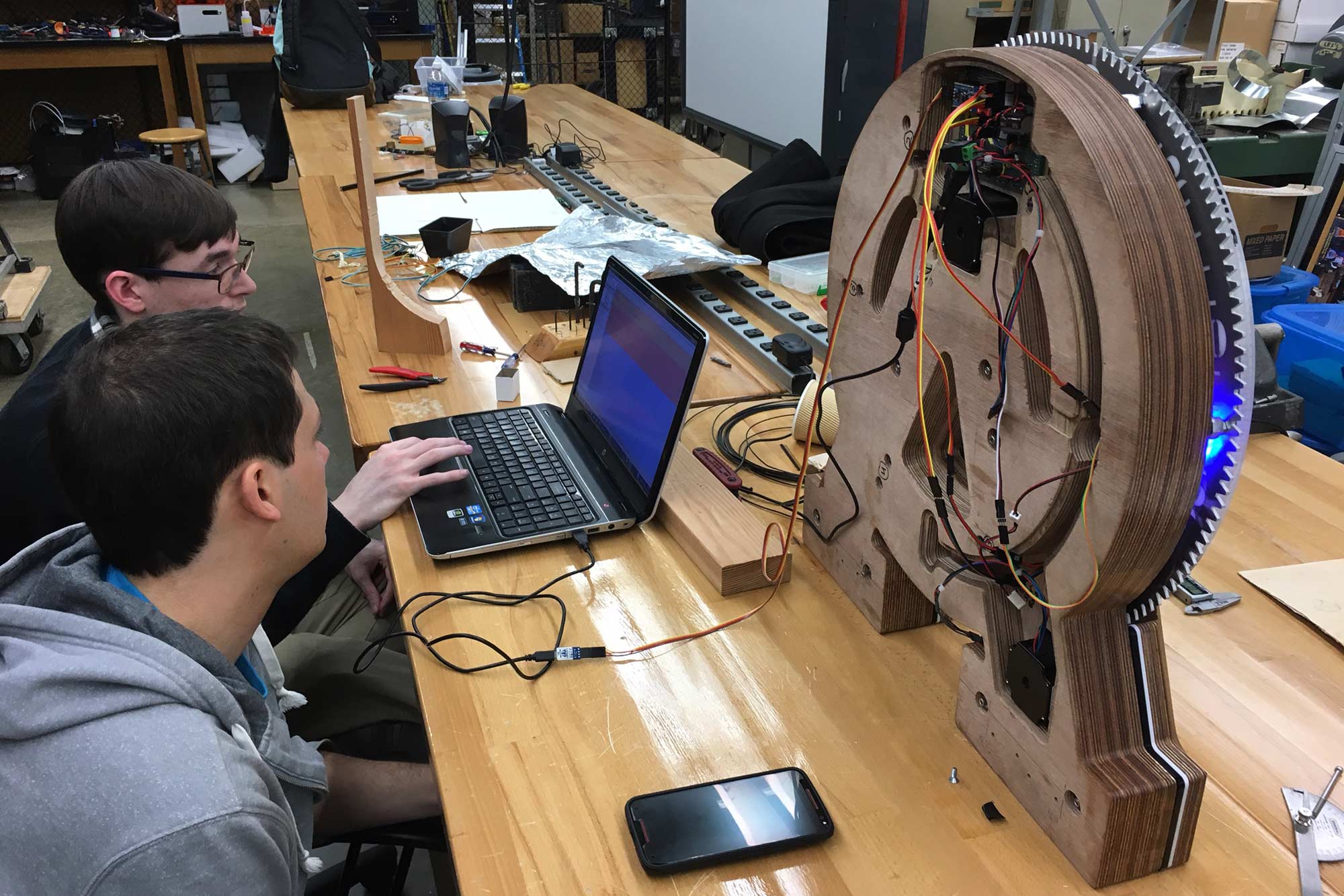 Two students using a computer to program a clock