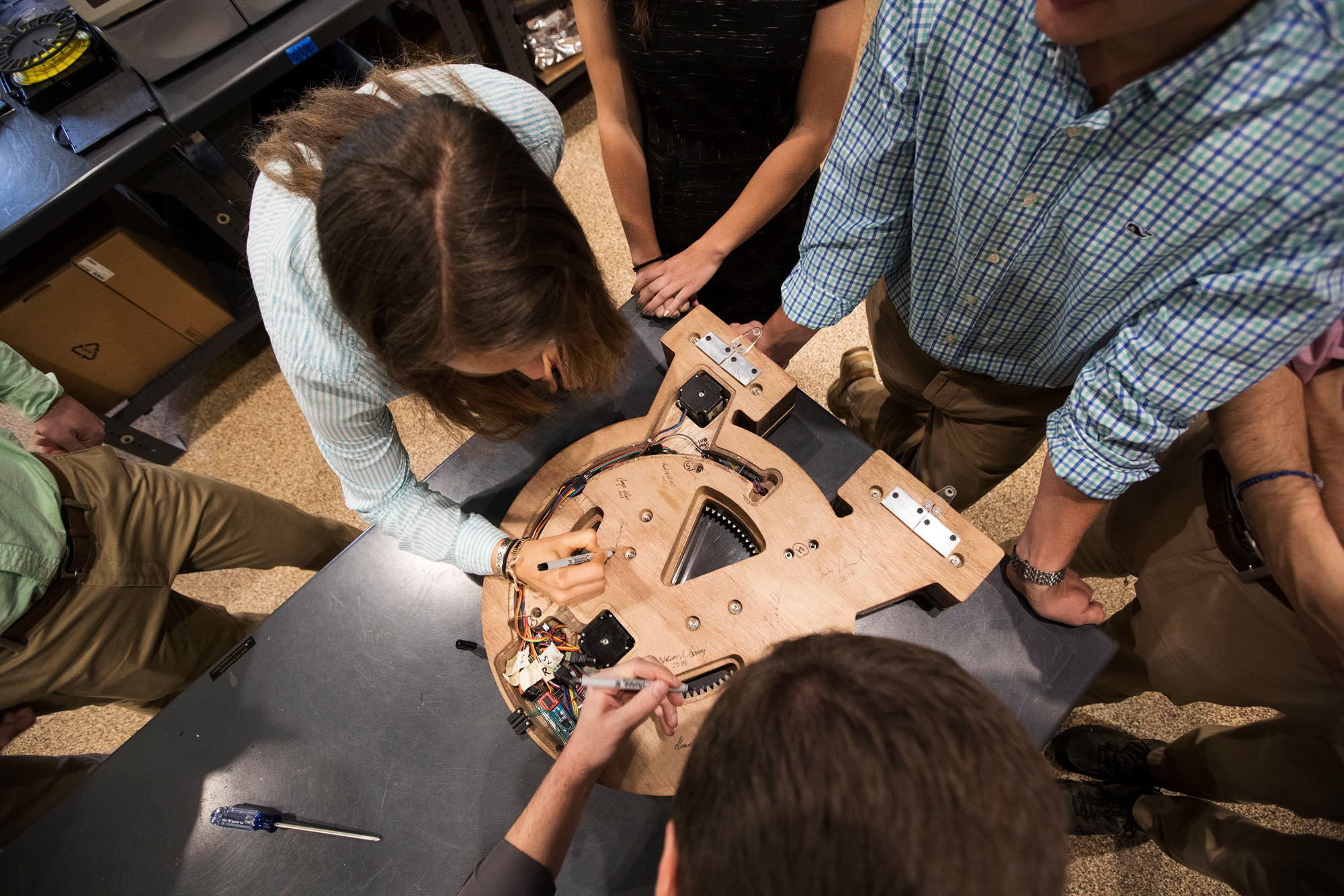 Students autographing the back of a clock