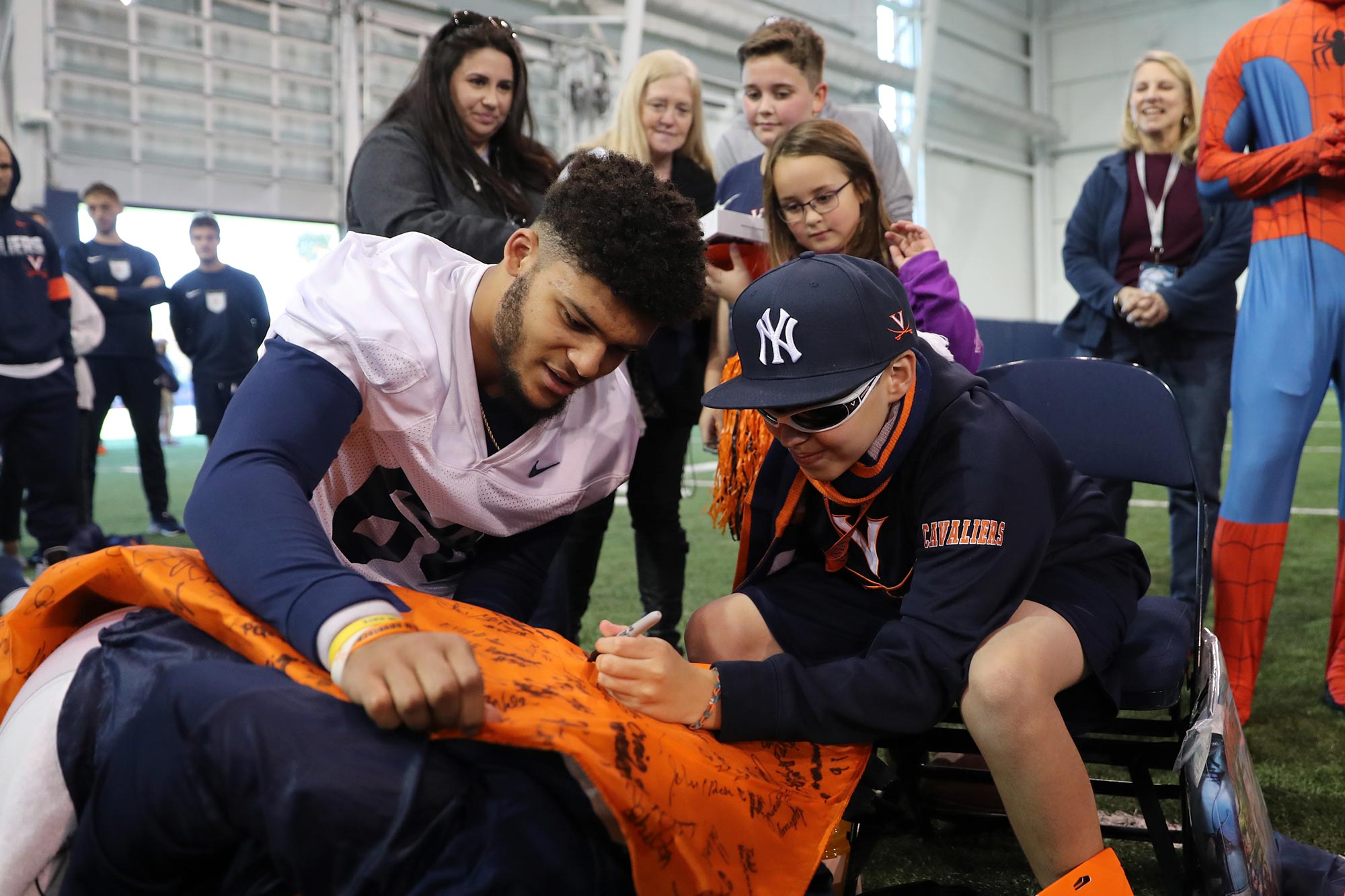 Chayce Chalmers helps a child sign a keepsake