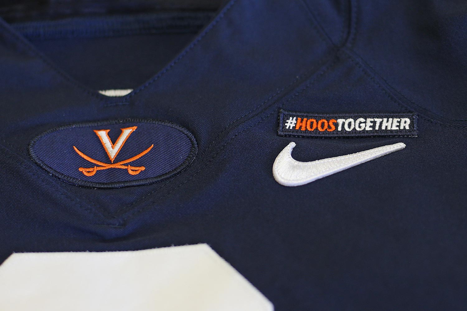 UVA athletic uniform with an up close view of the Virginia V saber and a patch that says #hoosTogether