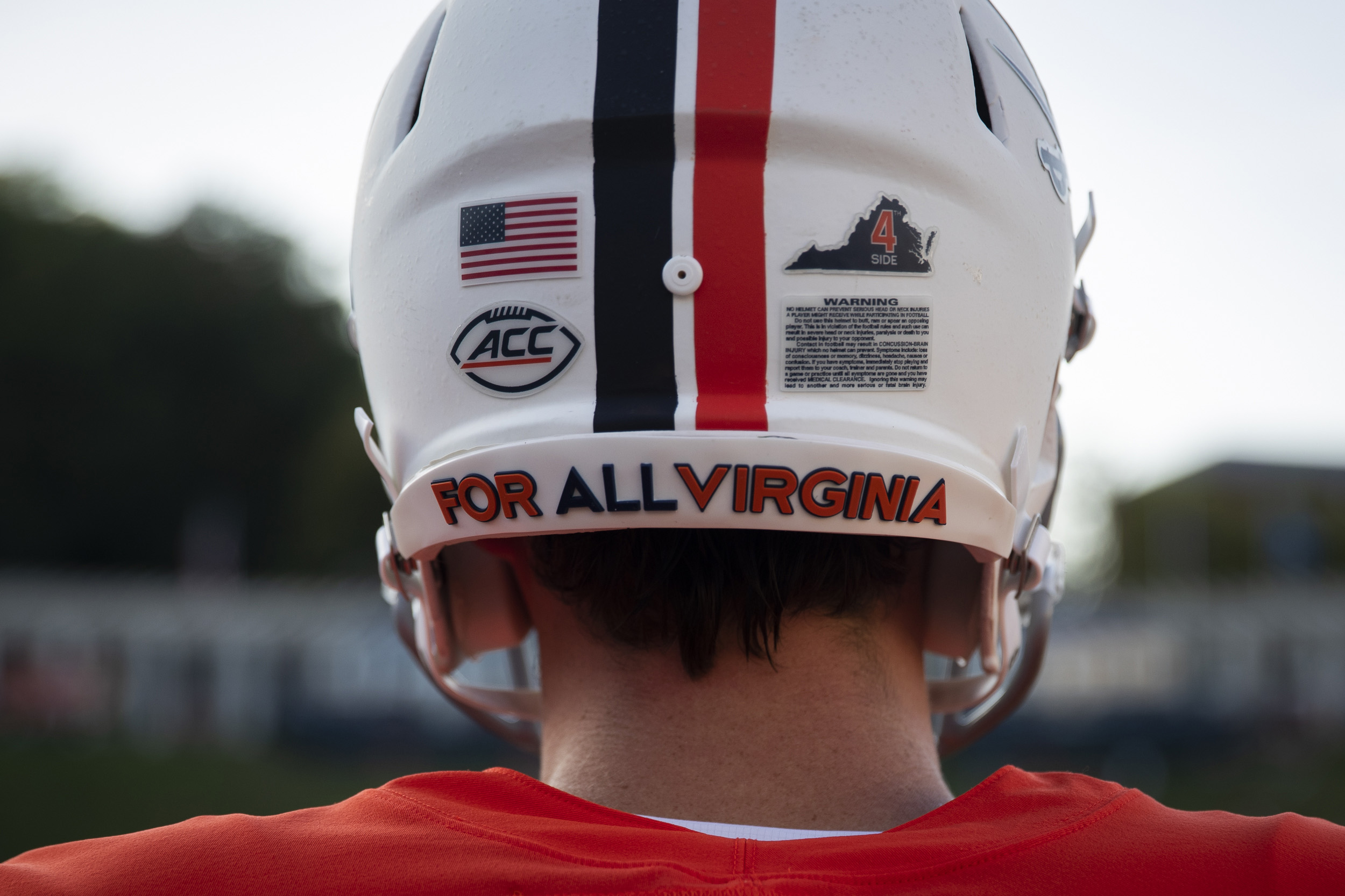 Back of a UVA football helmet that reads For All Virginia