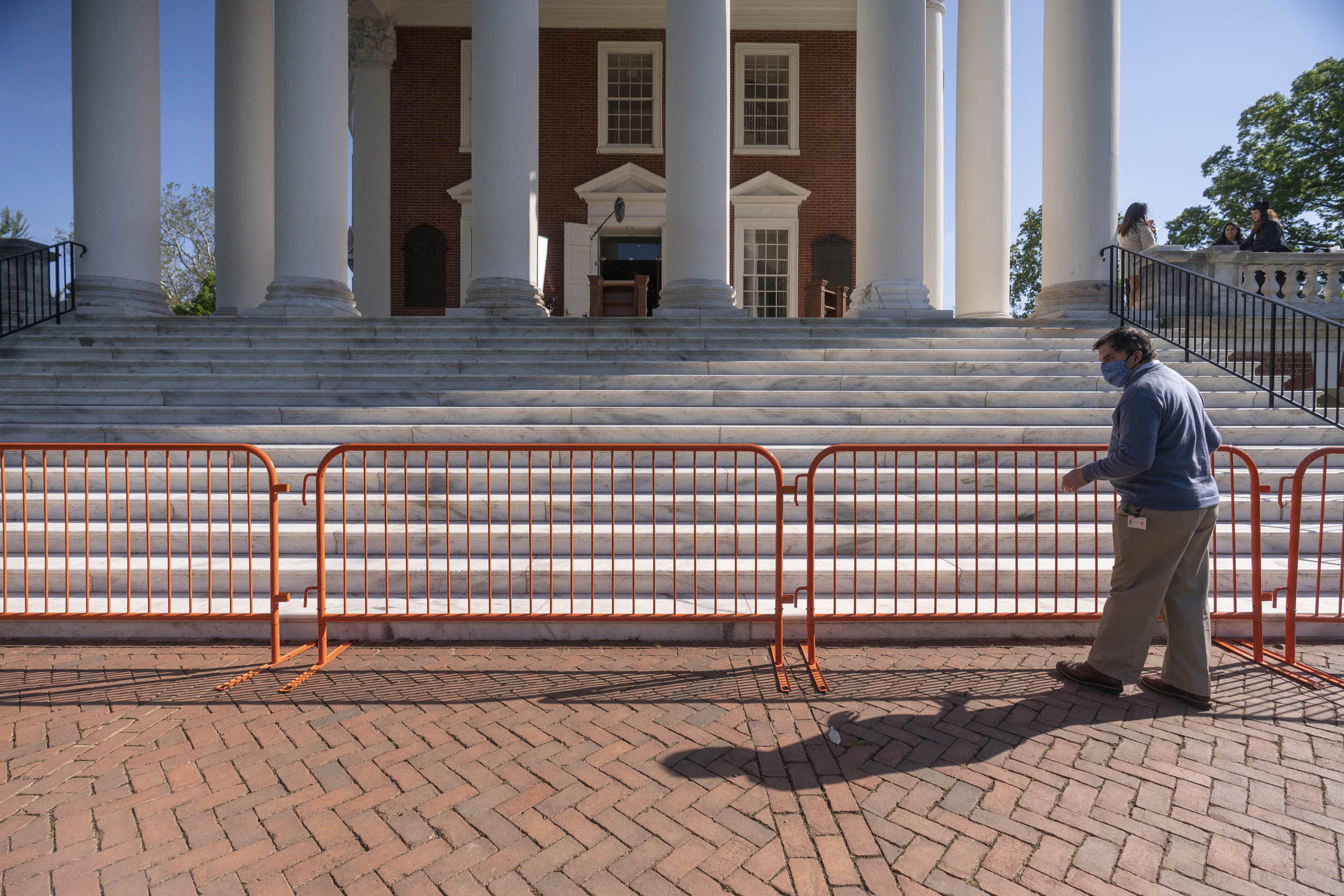 Staff member placing orange baracades in front of the Rotunda steps