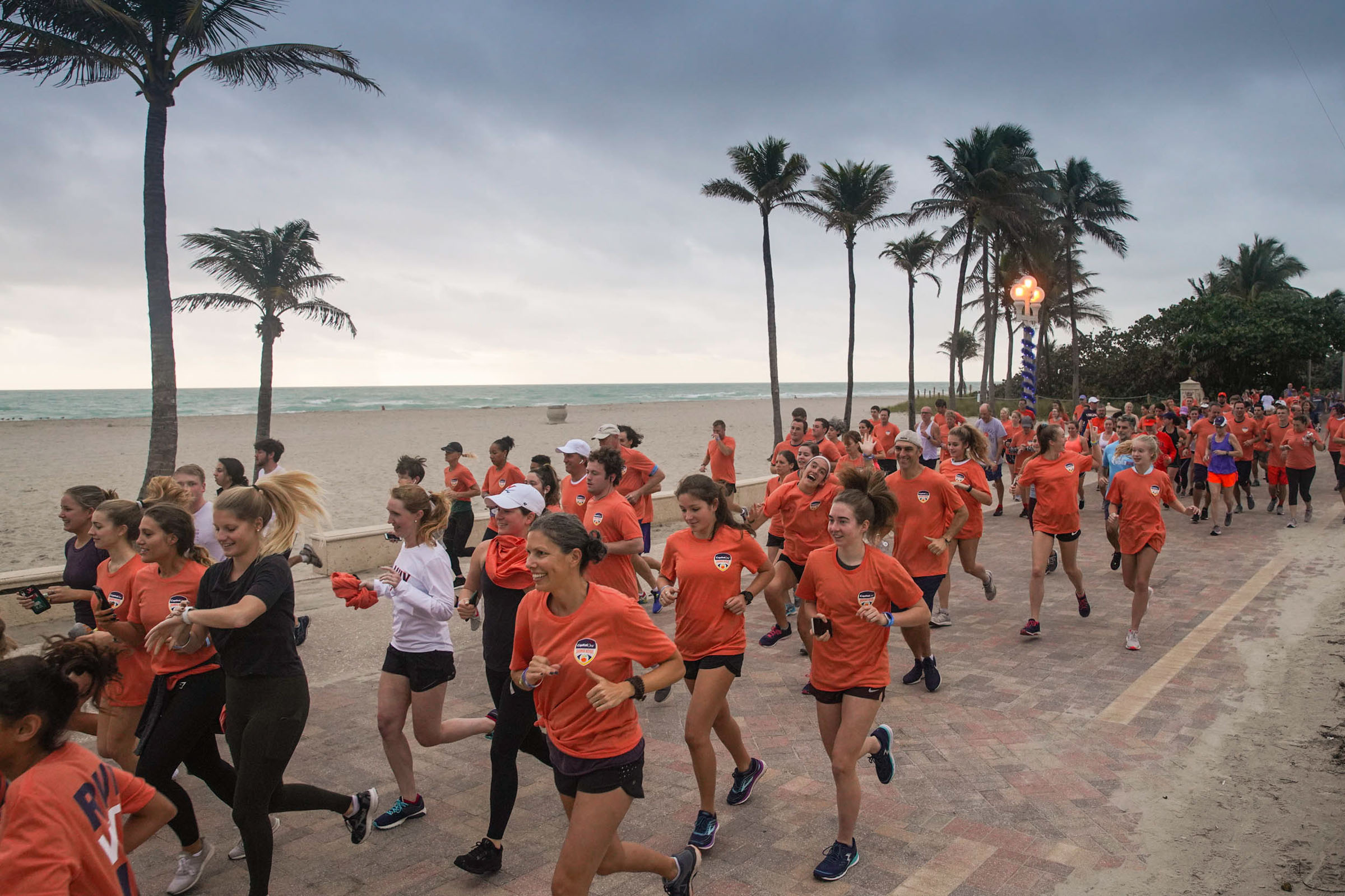 Group of people dressed in Orange running on the boardwalk