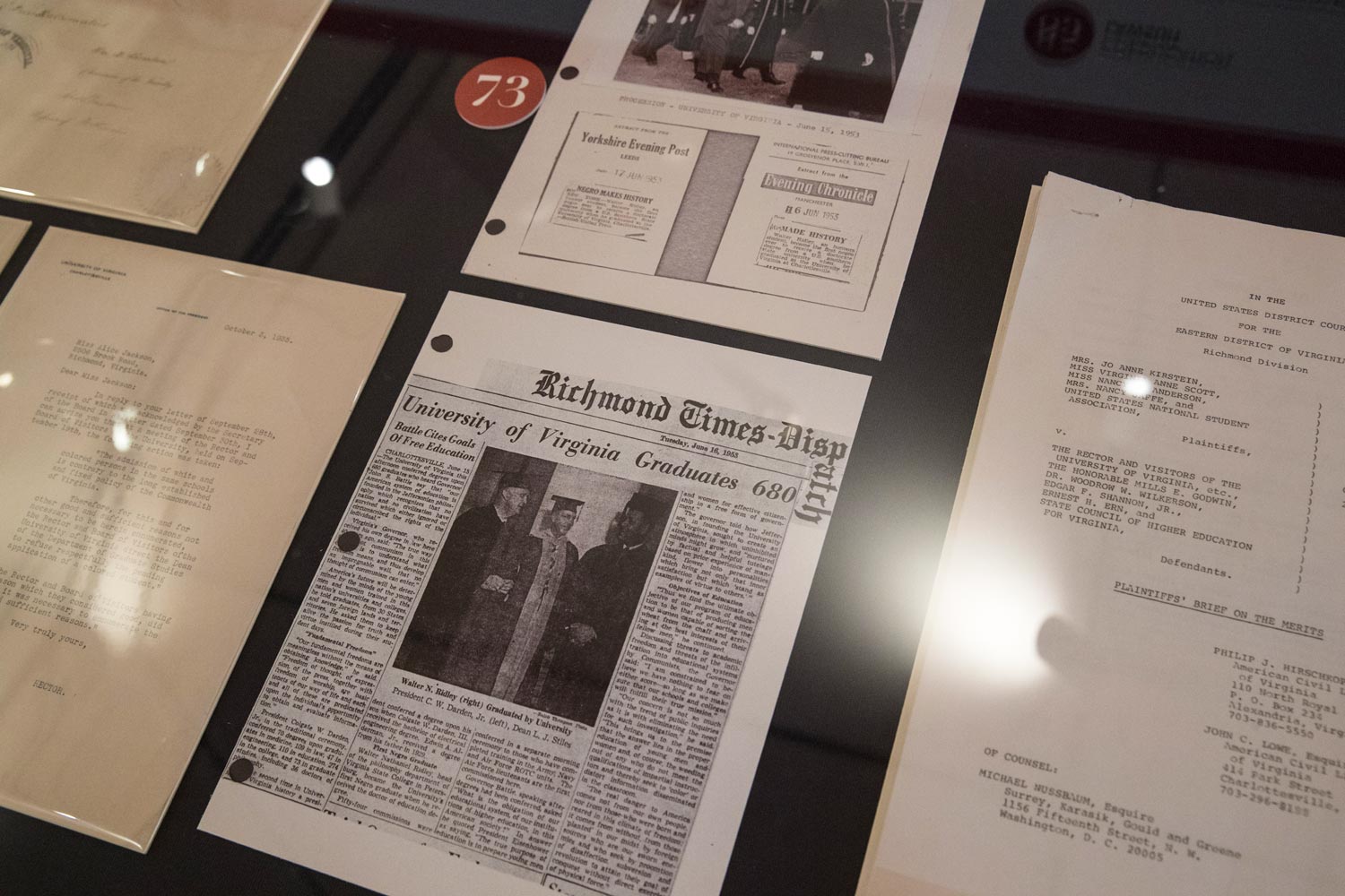 Several pages from a scrap book under a glass display case