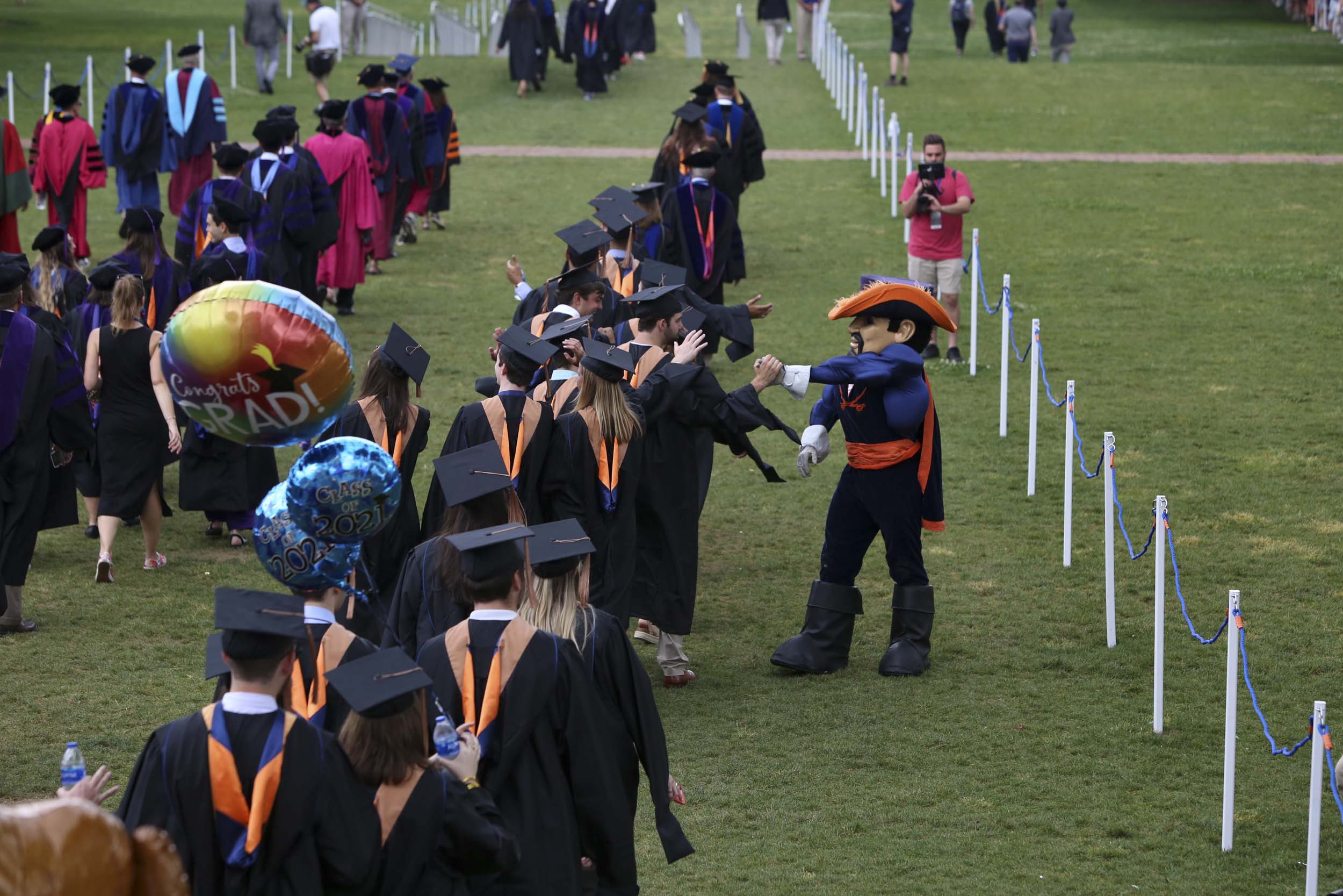 Cav Man high fiving graduates as they walk into final exercises