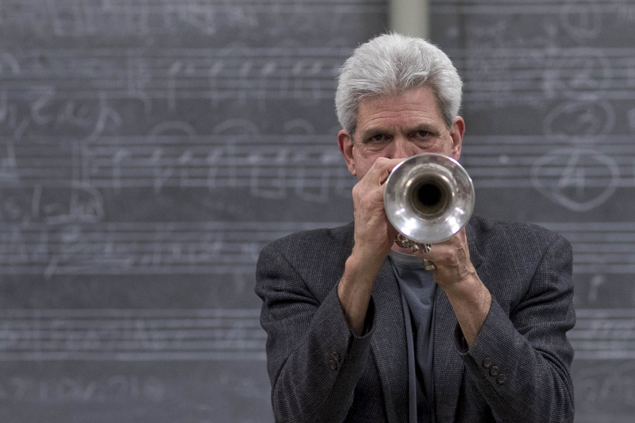 John Dearth playing the trumpet in front of a class