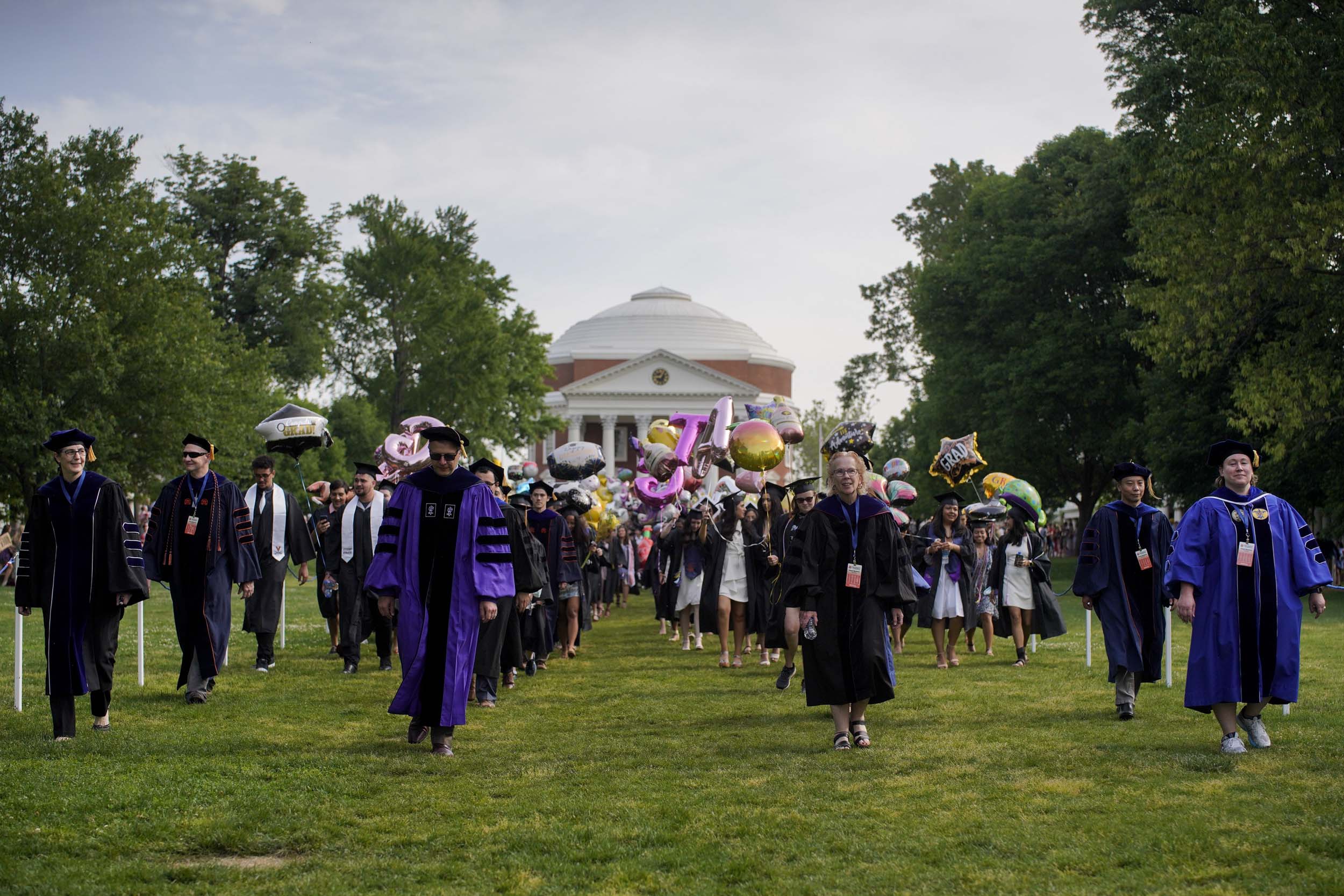 Graduates walking across the lawn from the Rotunda
