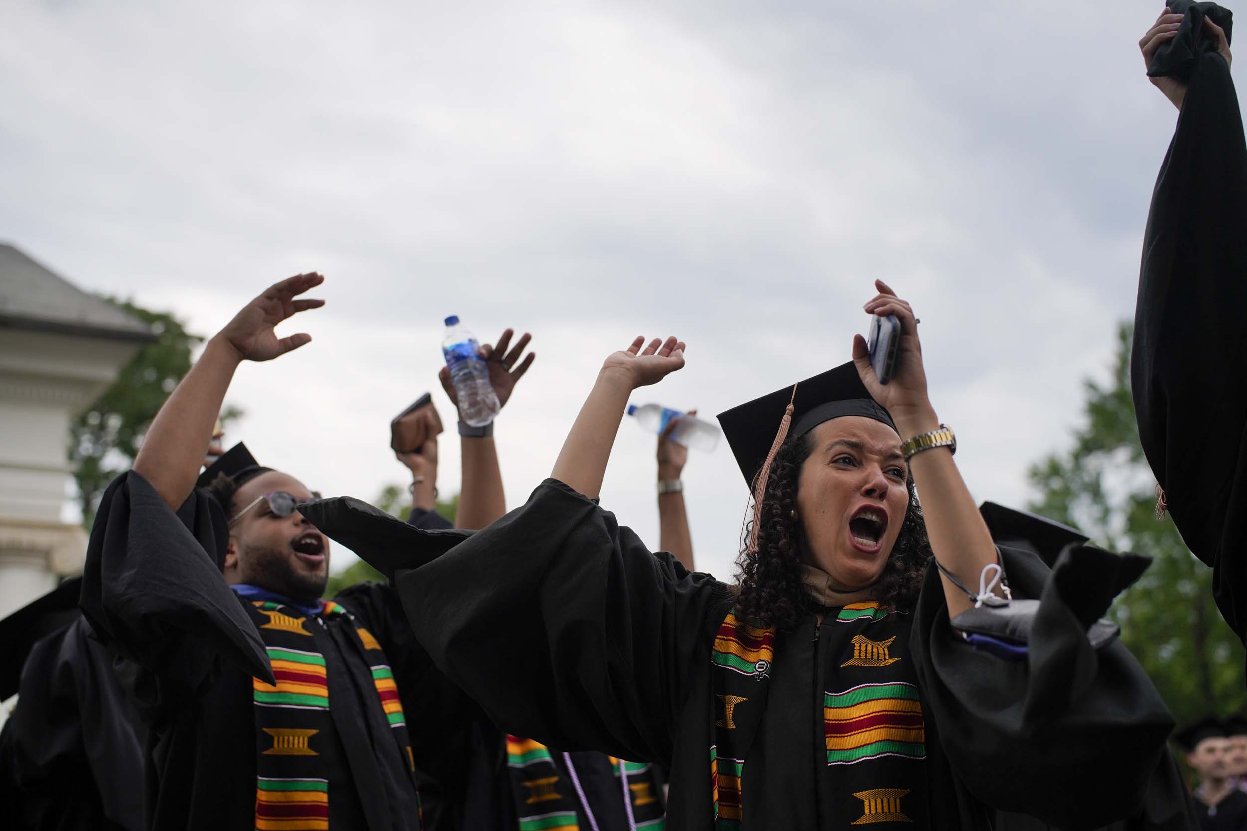 UVA graduates raising their hands and singing