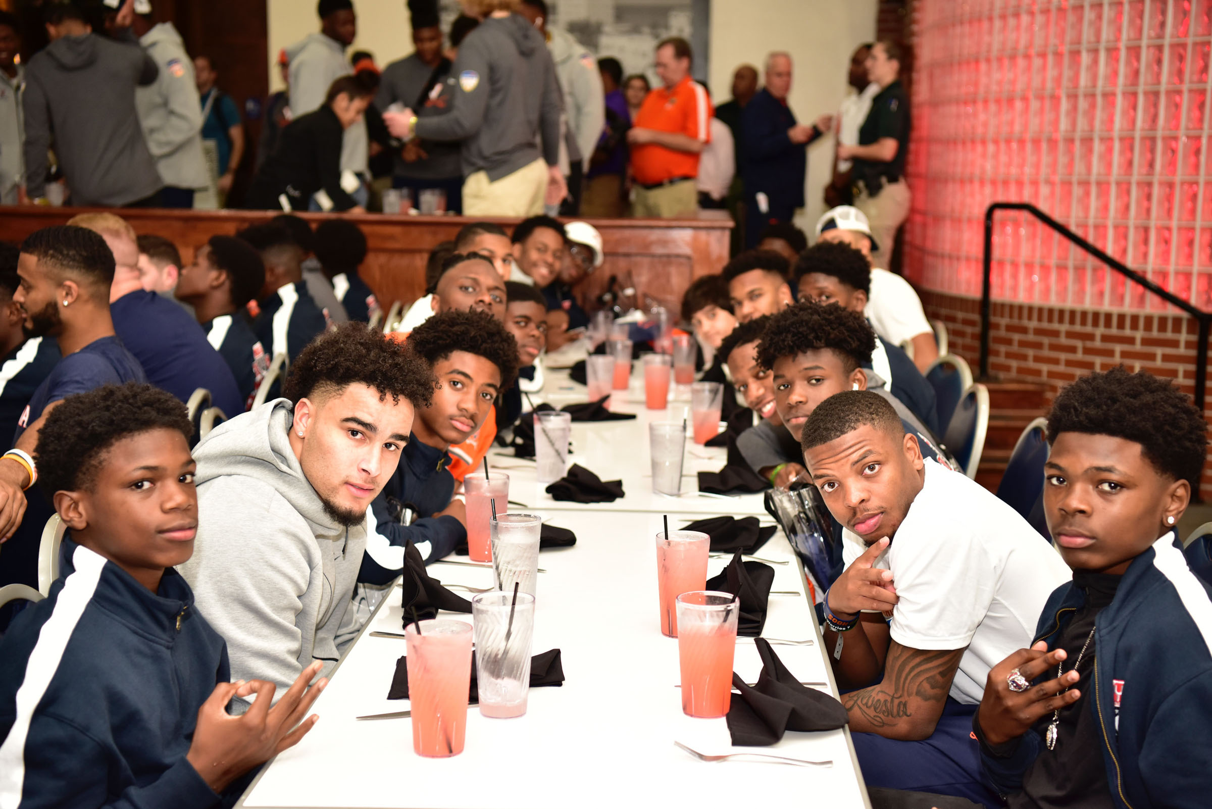 UVA football team sitting at a table with members of the Florida youth Football League