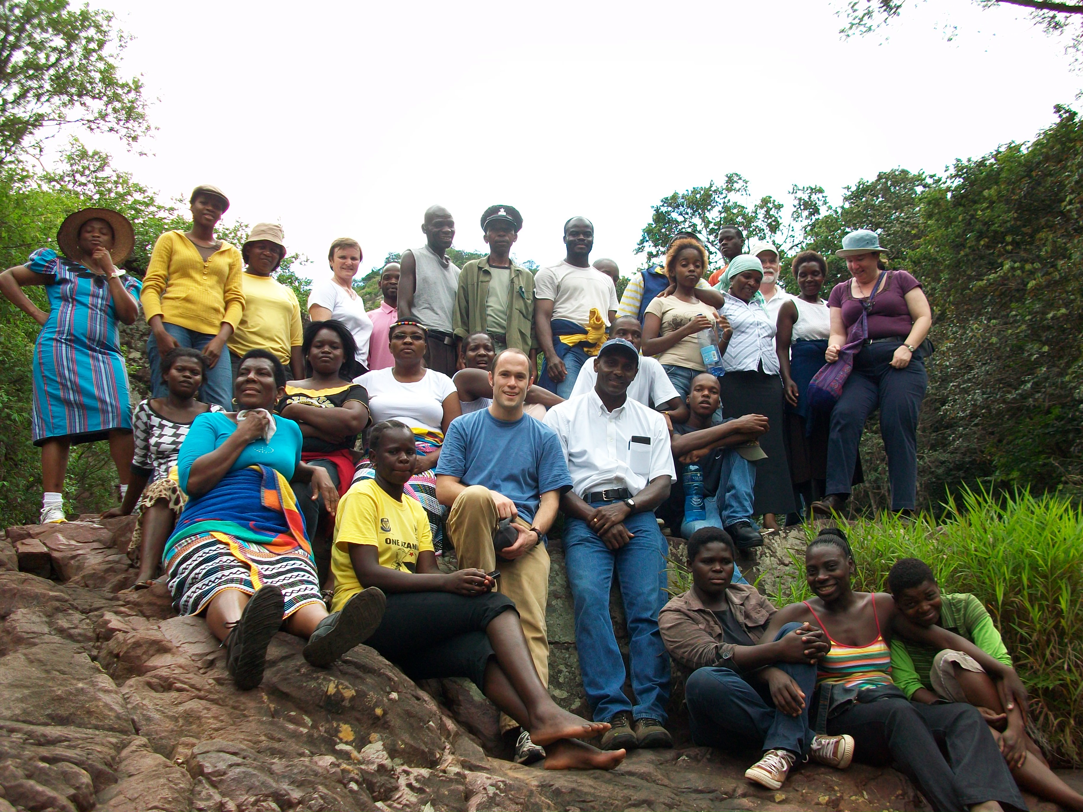 Group photo of a man and a village that he helped