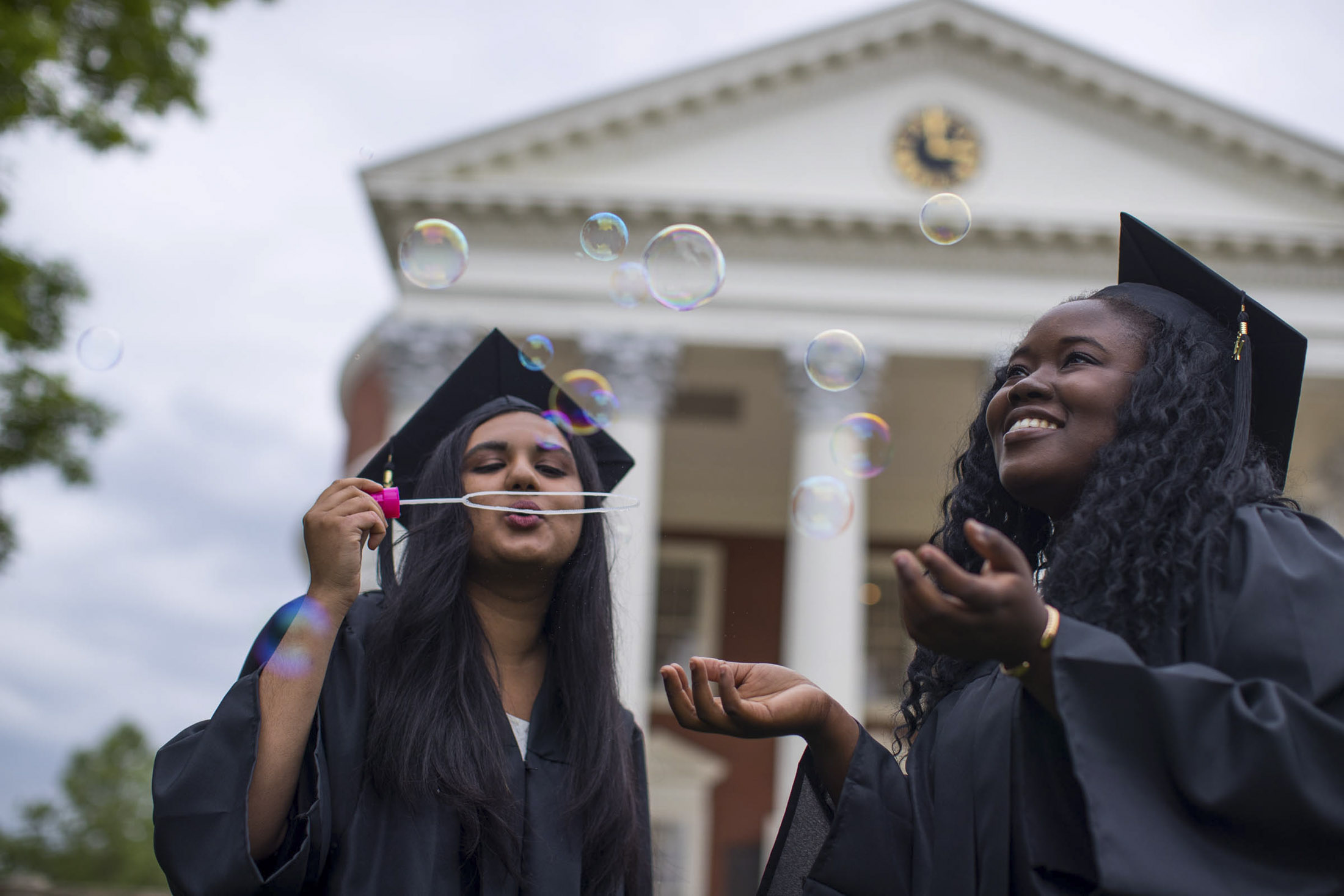 Graduates blowing bubbles in their caps and gowns