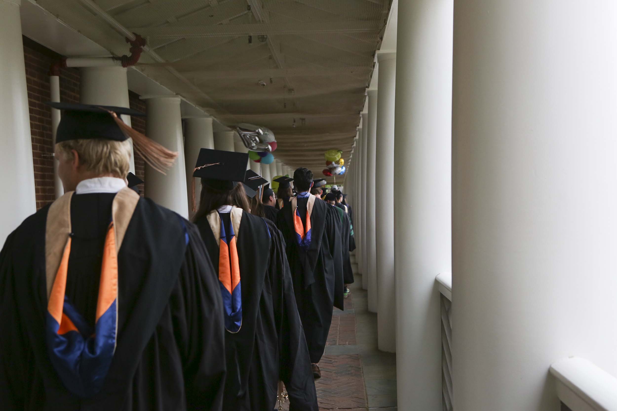 Graduates walking under the covered sidewalks on the Lawn