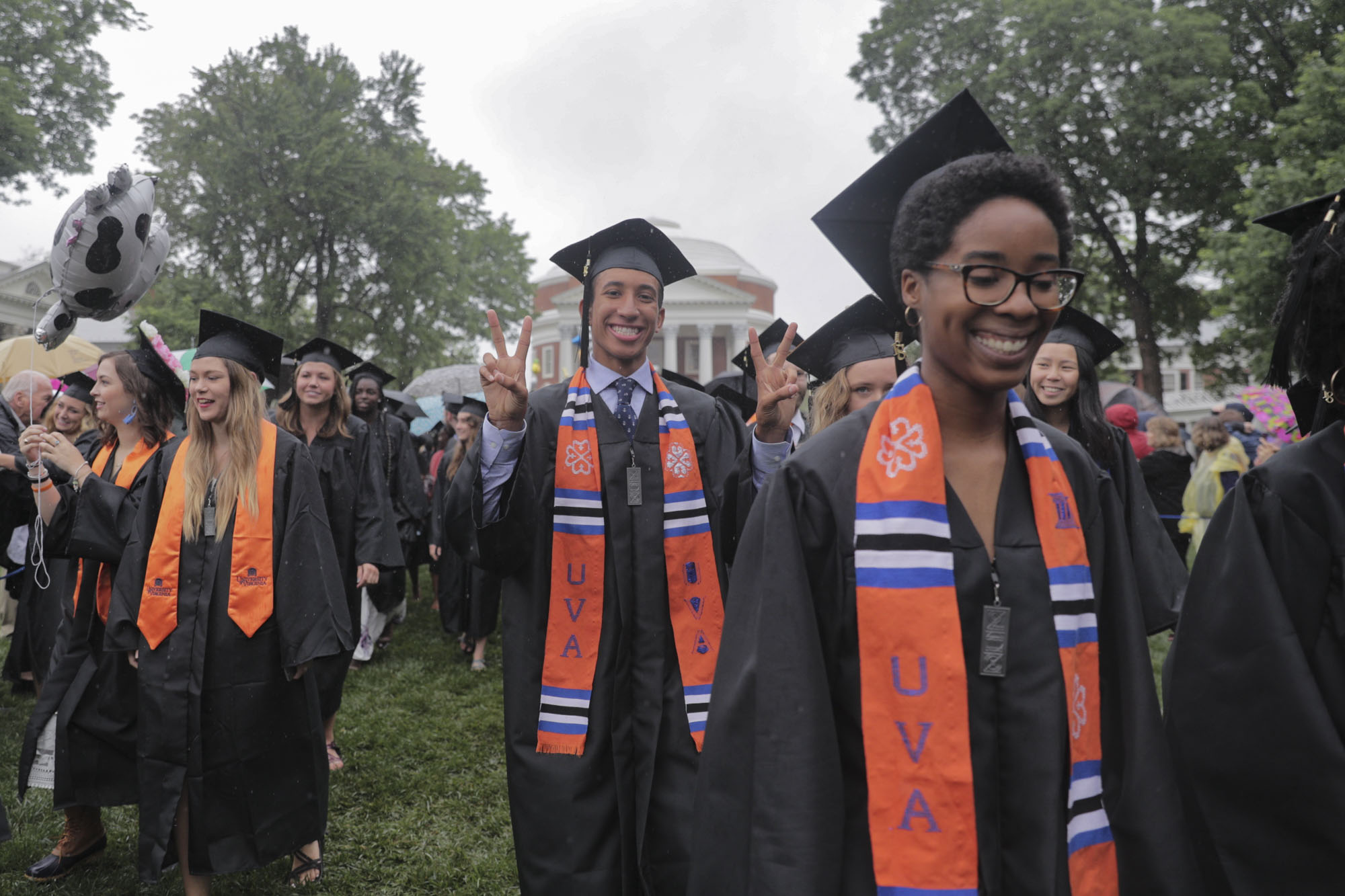 Graduates walking across the lawn from the Rotunda to her seats