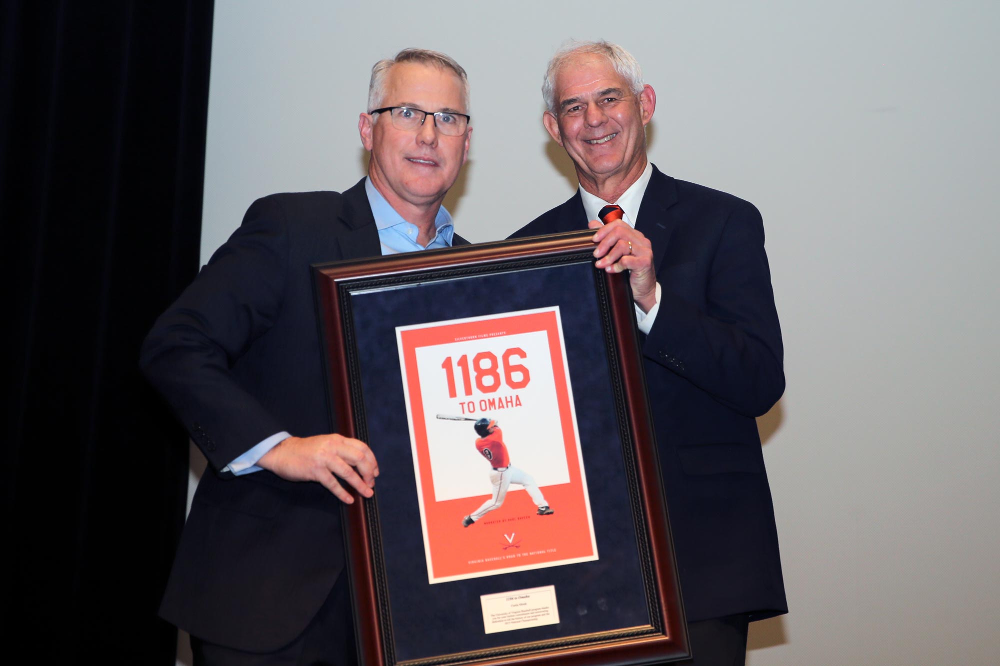 Brian O’Connor, left, presents Curtis Monk, right, with a framed movie poster that reads 1186 to Omaha
