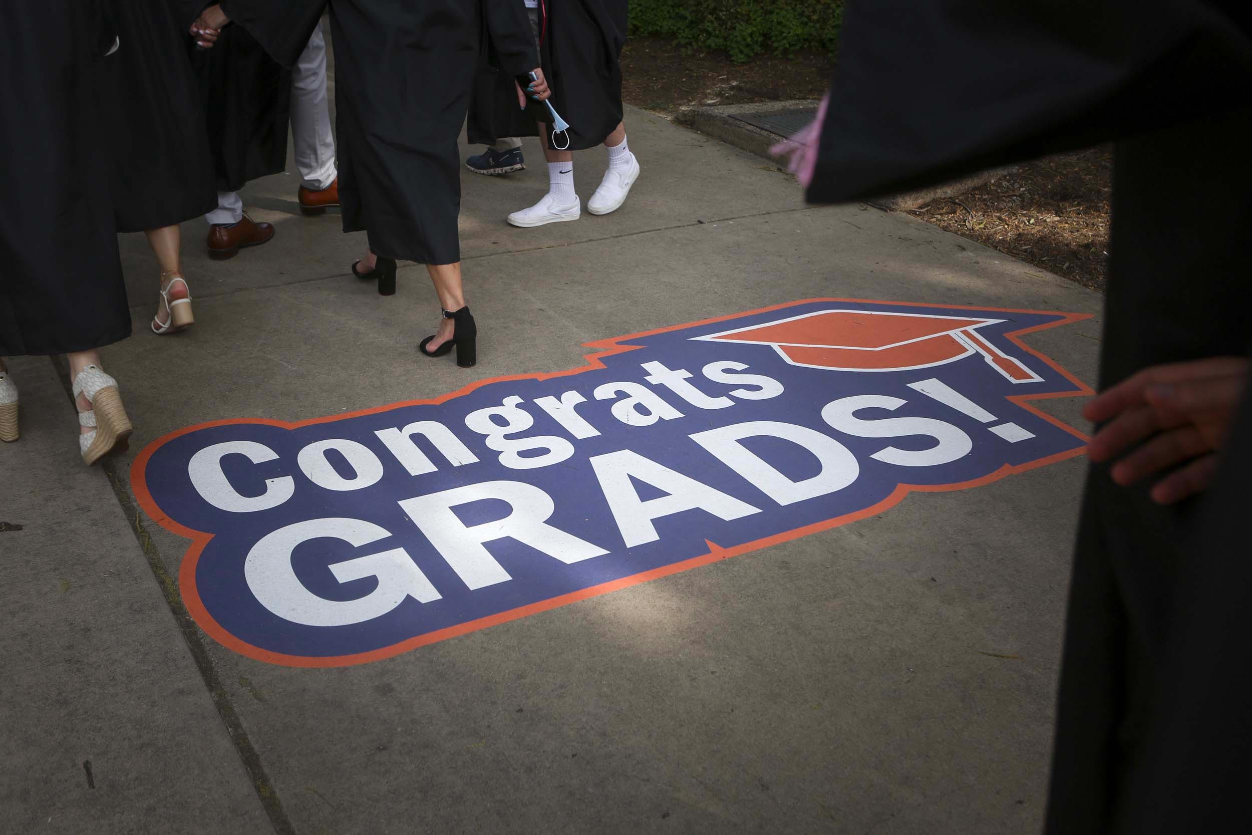 Sign on the ground that reads Congrats Grads