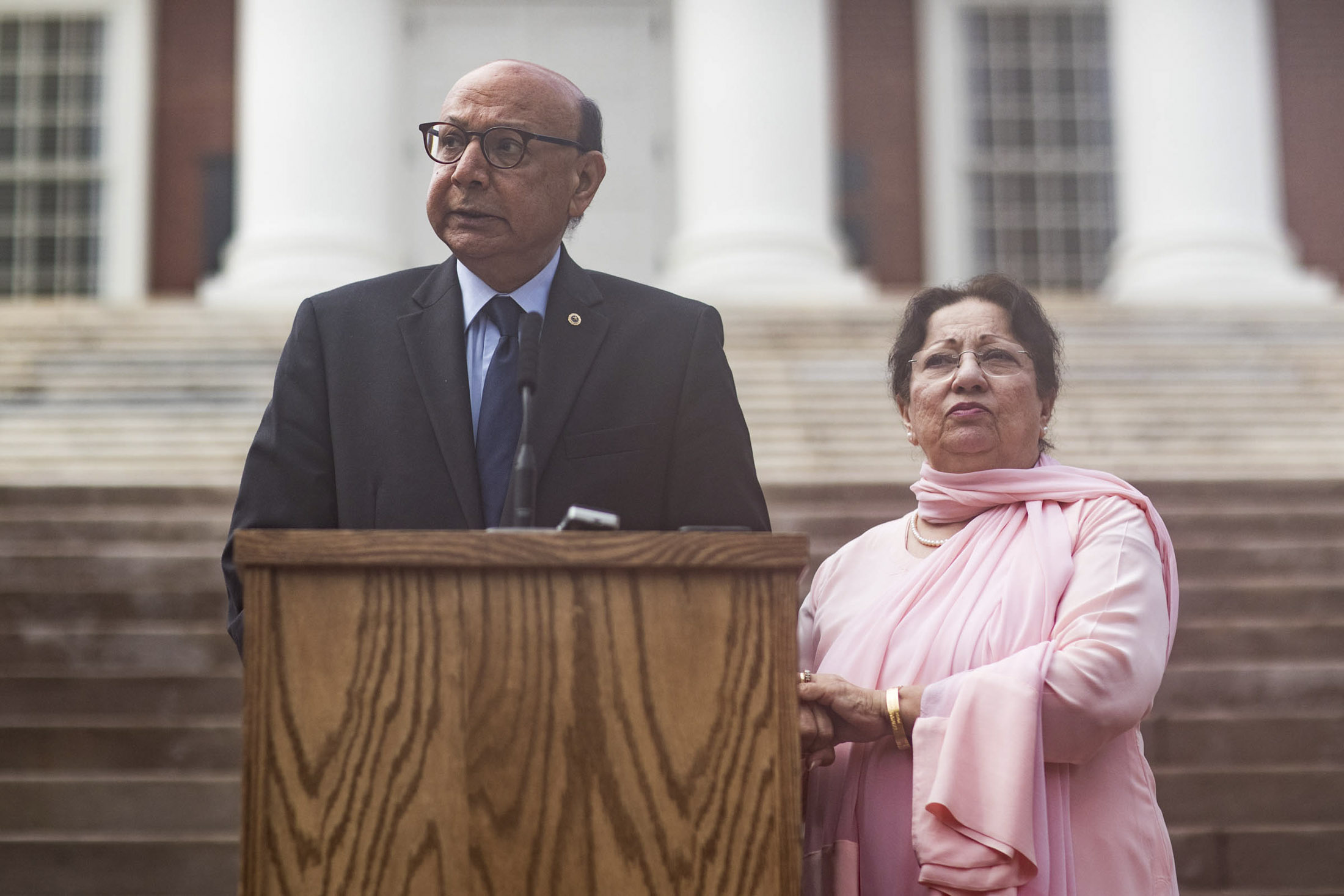 Two people standing at a wooden podium