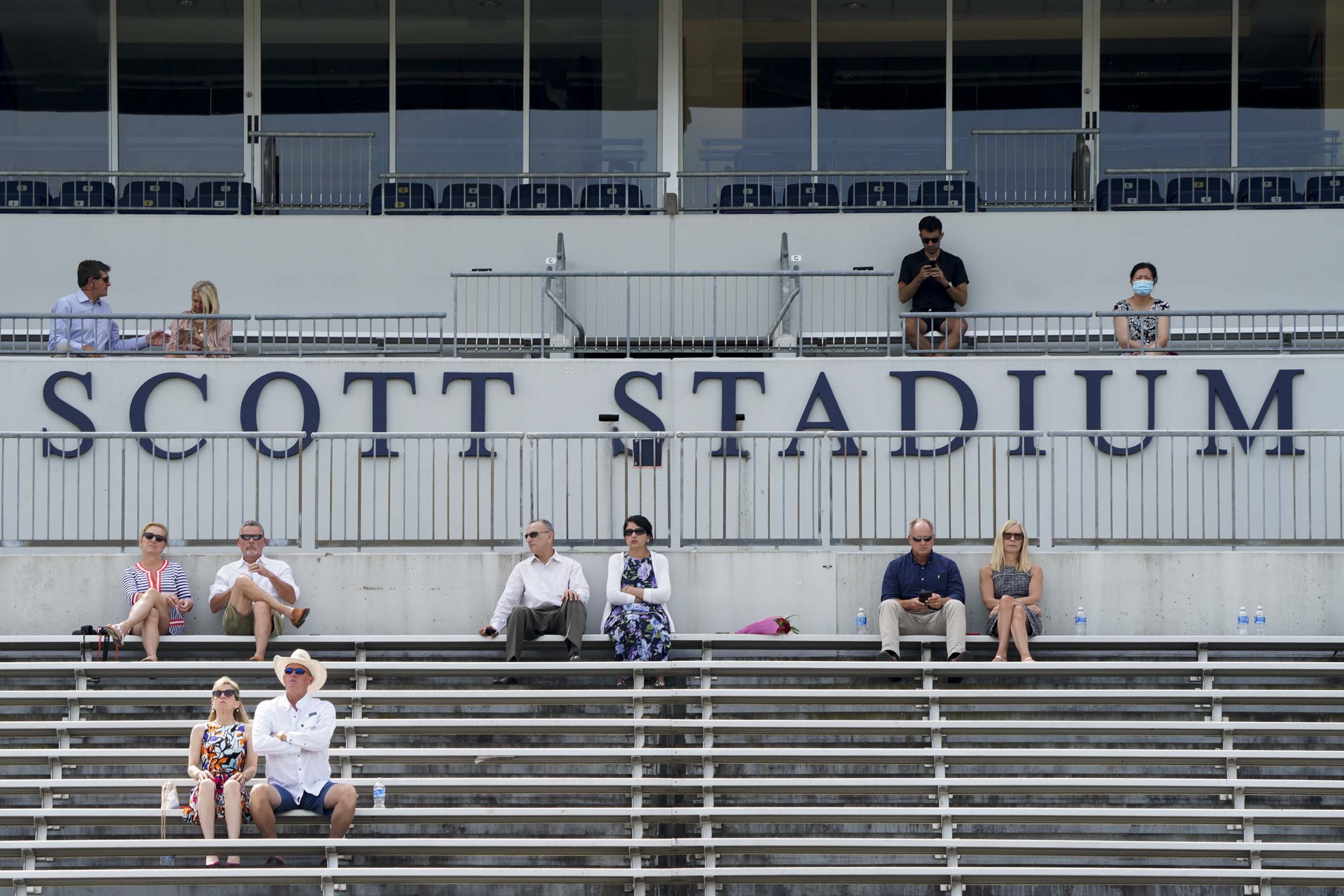 Families sitting in the scott stadium bleachers socially distanced at final exercises