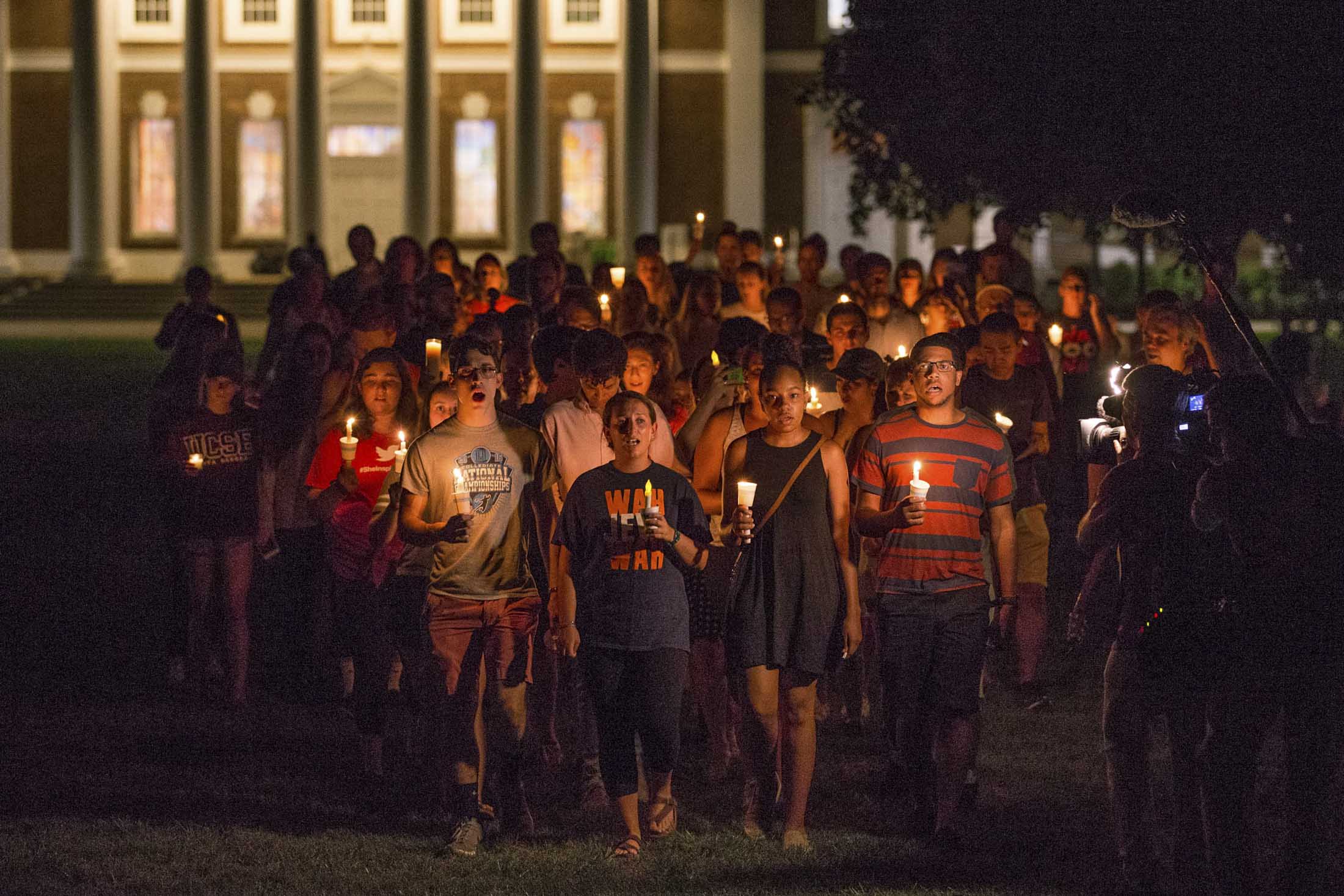 Students walking with candles at night