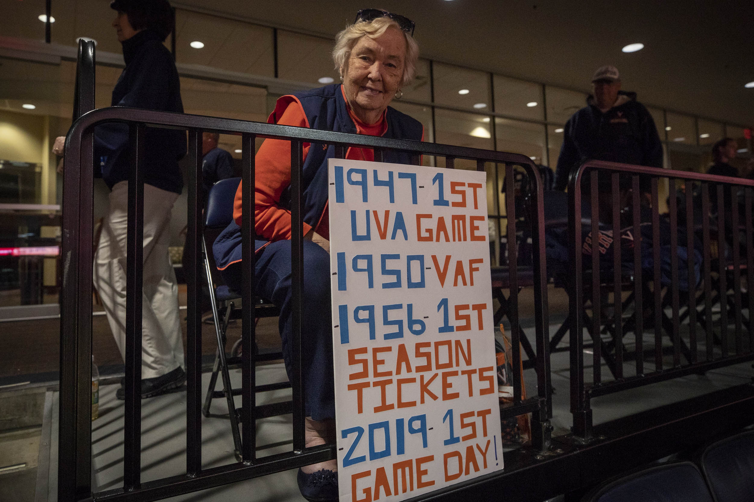 Woman holding a sign that says: 1947 - 1st live game 1950 - VAF 1956 - 1st season tickets 2019 - 1st game day!