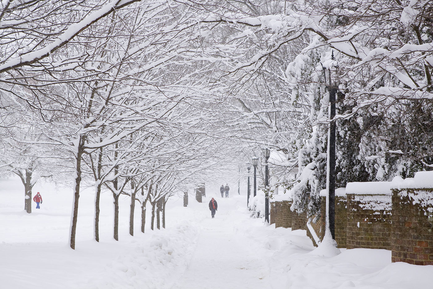 people walking on snow covered sidewalks