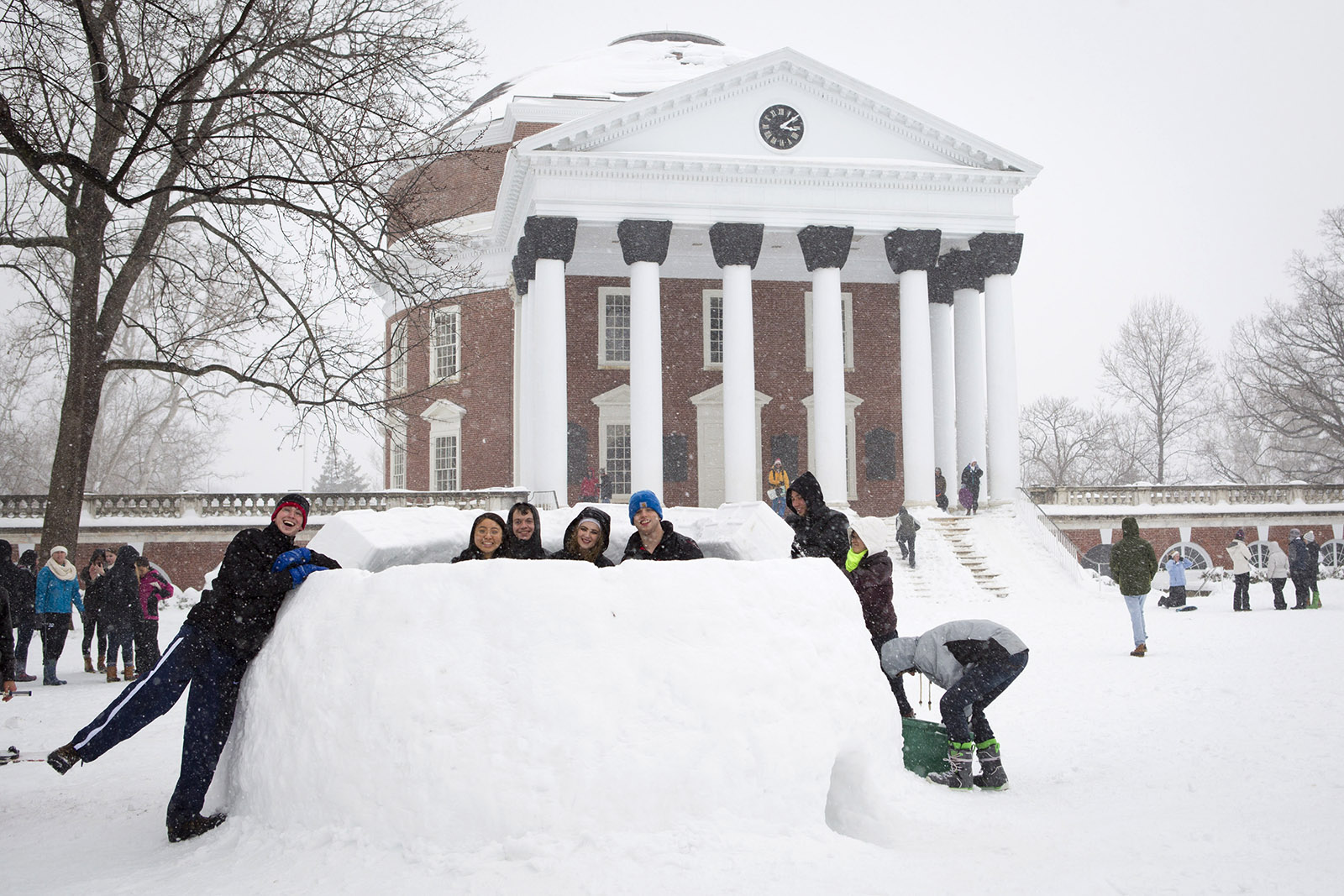Students creating a snow fort in front of the Rotunda