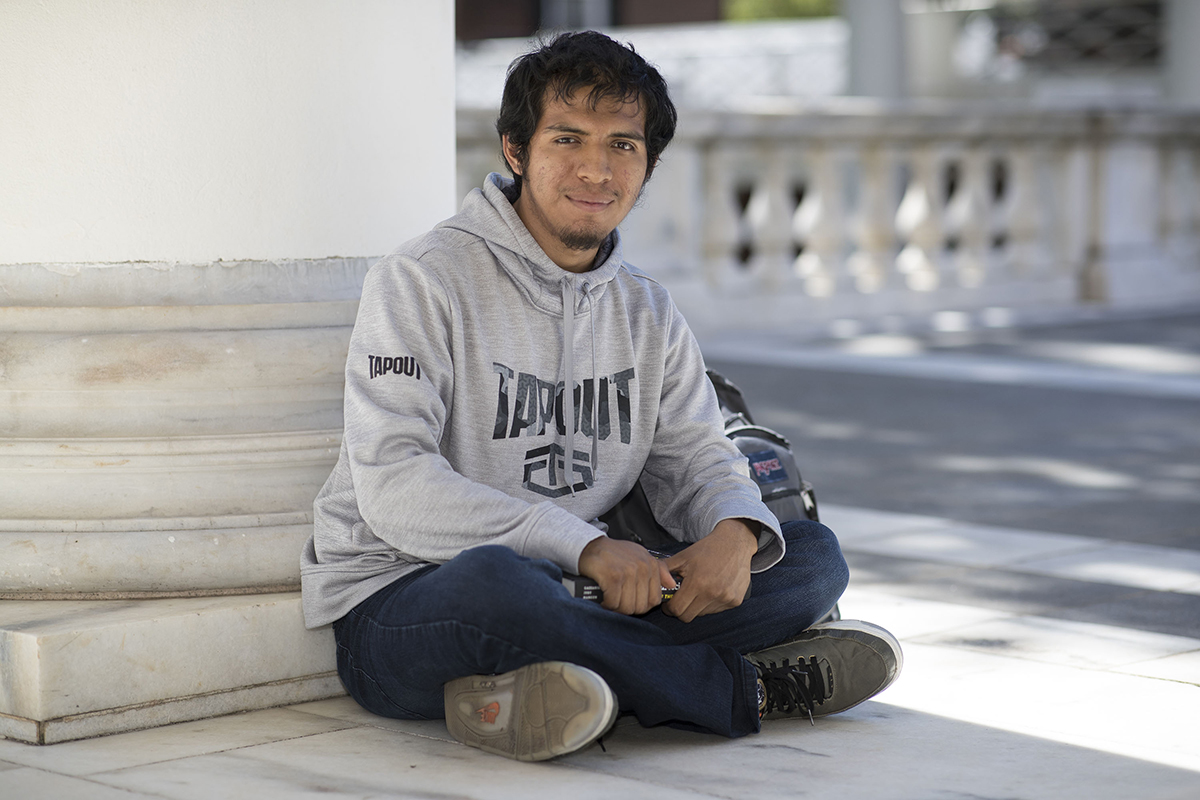 Student sitting at the base of a Rotunda Column facing the camera