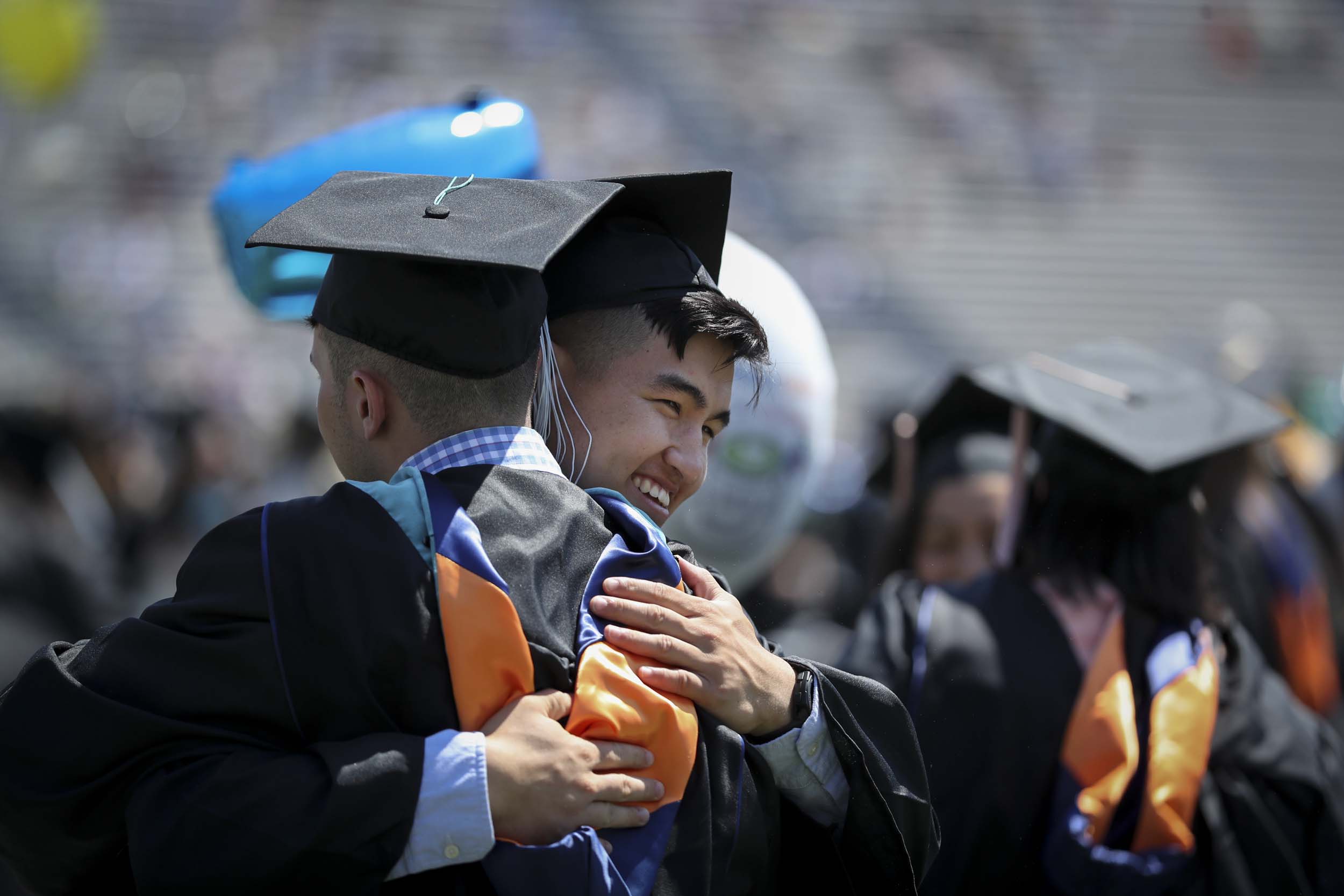 two UVA graduates hug each other at graduation