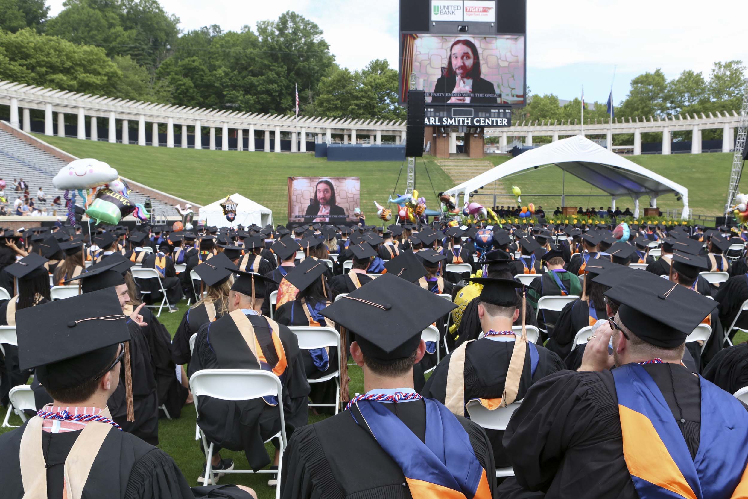 Graduates watching the big screen as a video is played