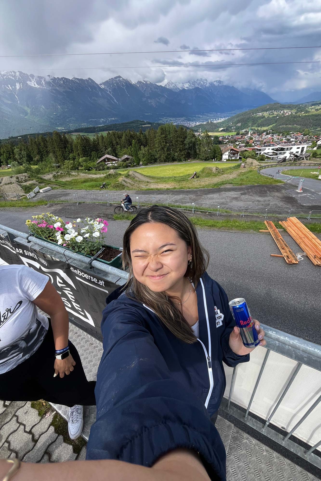 Selfie of Khuyen (in navy jacket, holding Red Bull can and with mountains in background)