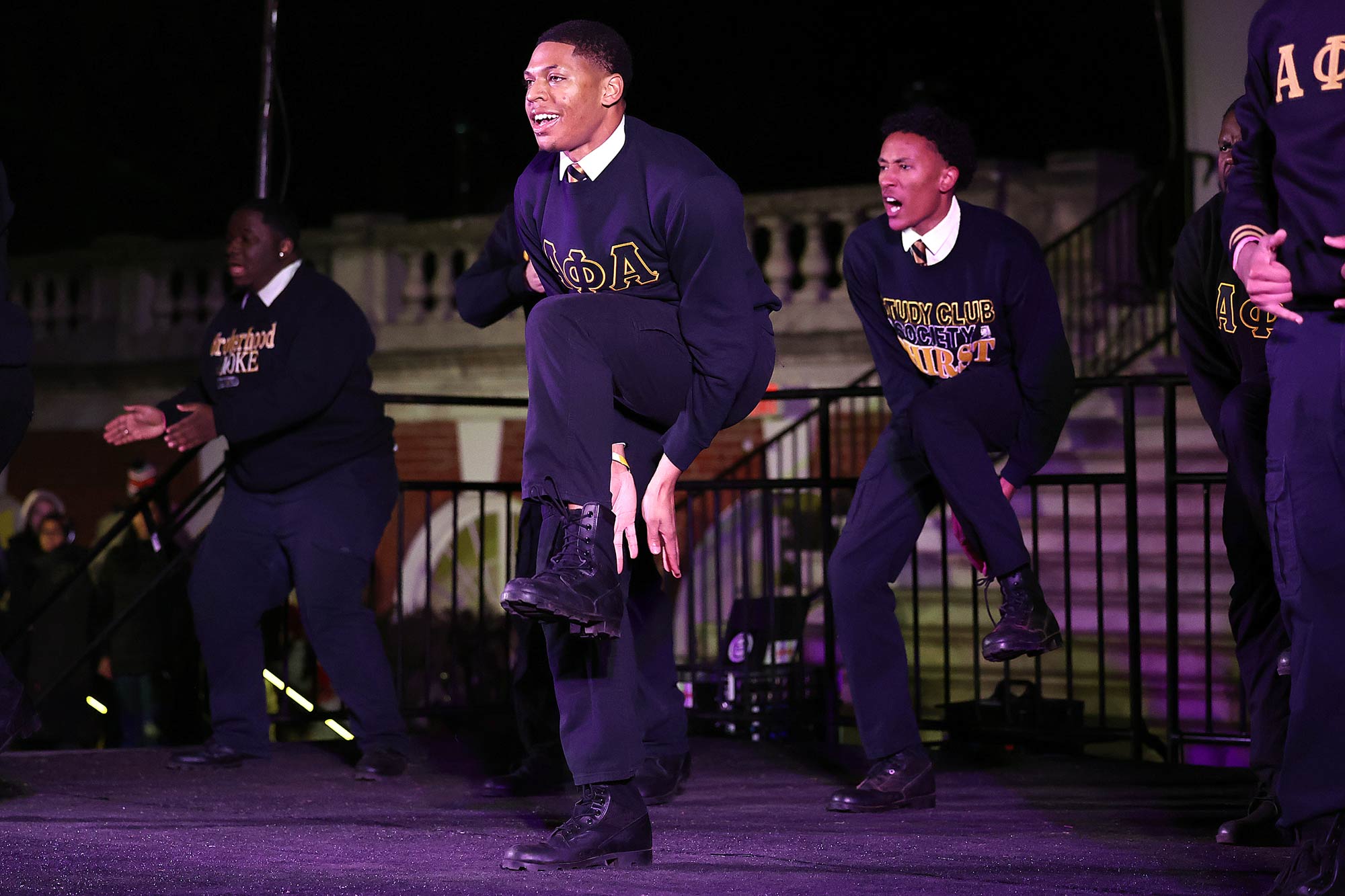 Dancers clap under lifted legs as they perform their routine