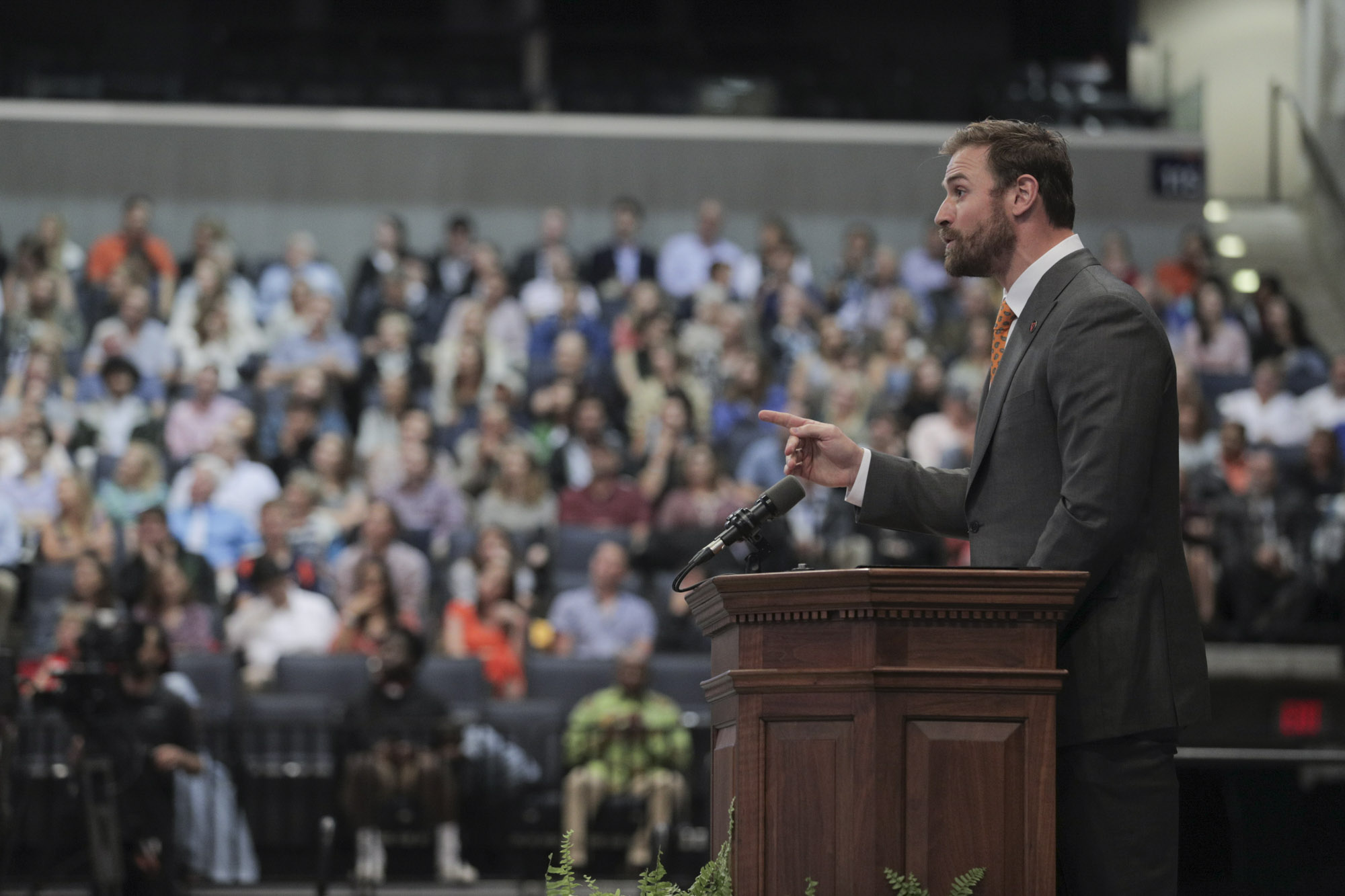 Chris Long speaking at a podium to a crowd