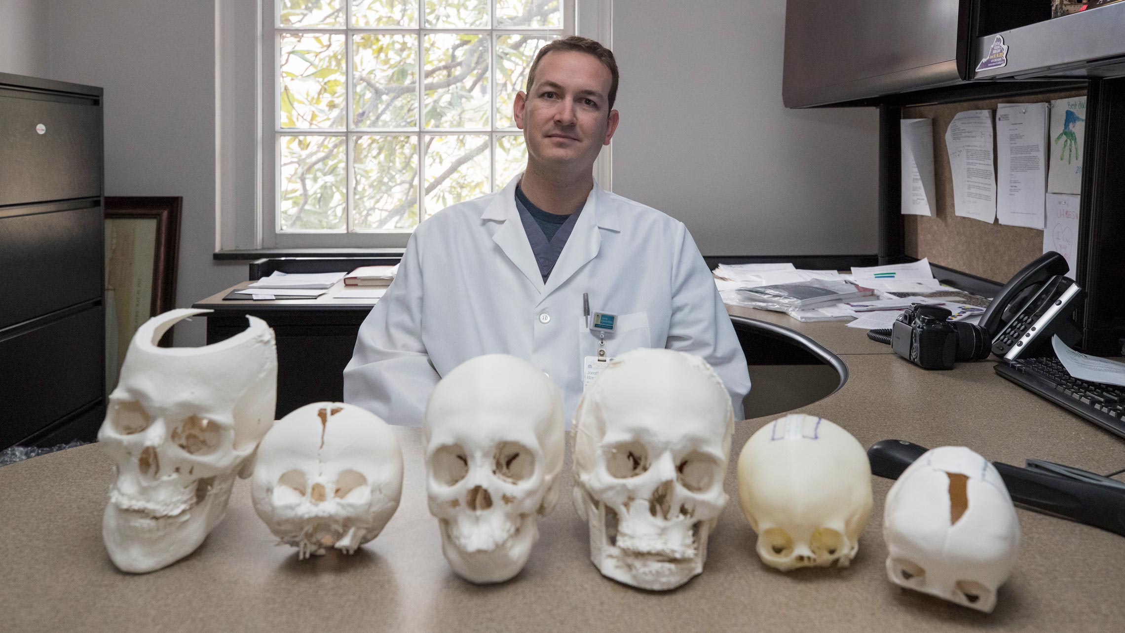 Johnathan Black sits in front of various looking skulls