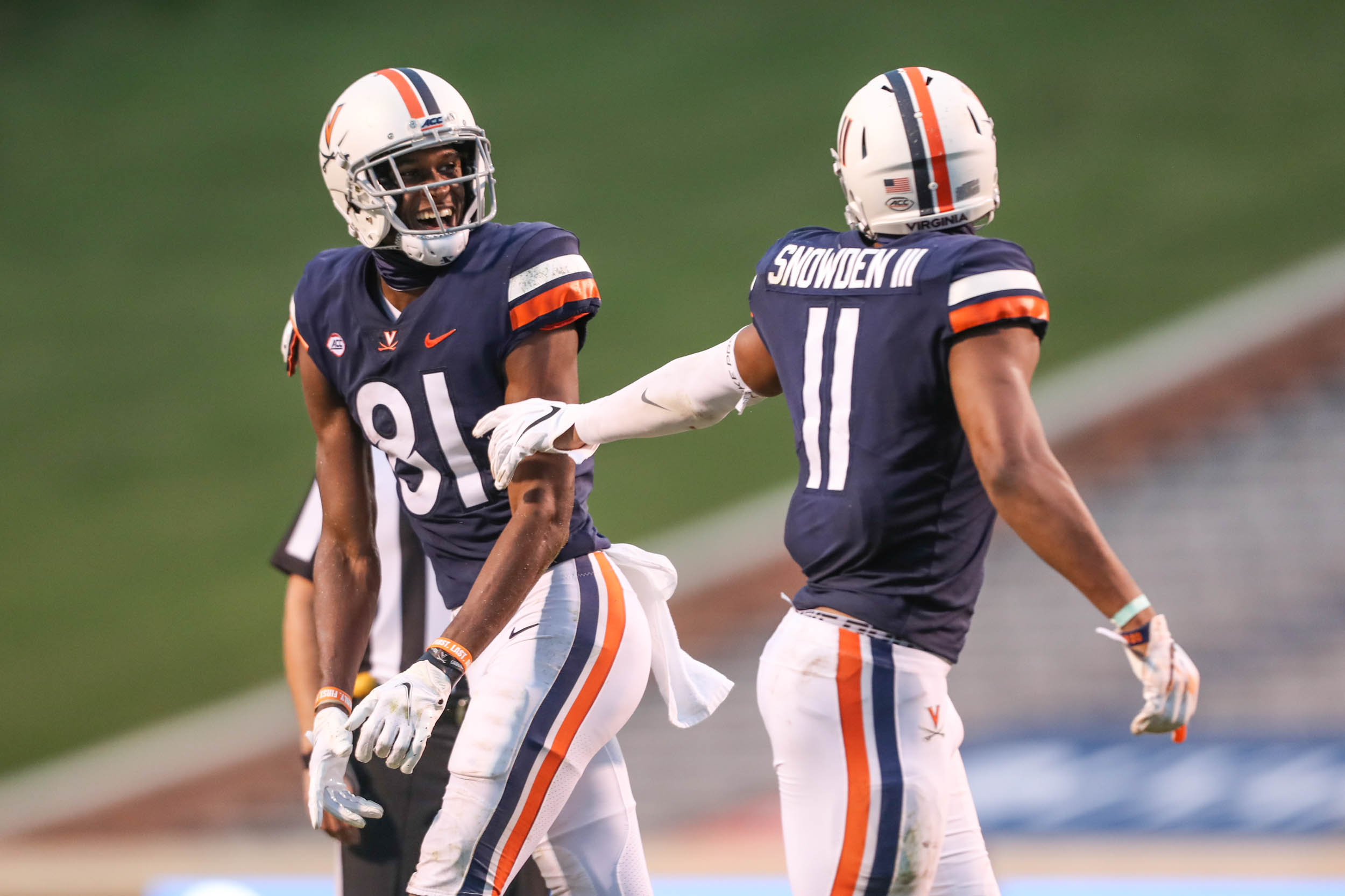 Lavel Davis Jr., left, and  Charles Snowden, right talk on field during a game