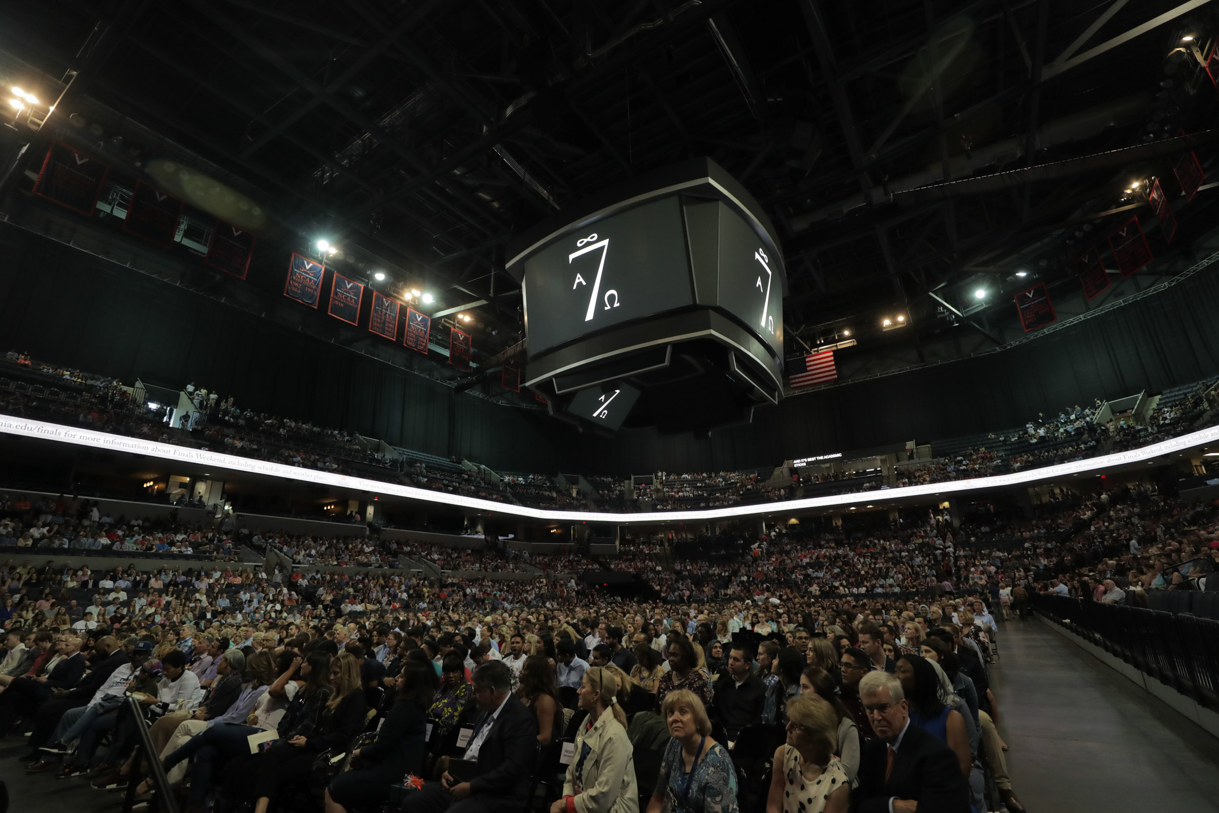 John paul jones arena filled with people with the 7 society banner on the jumbo tron