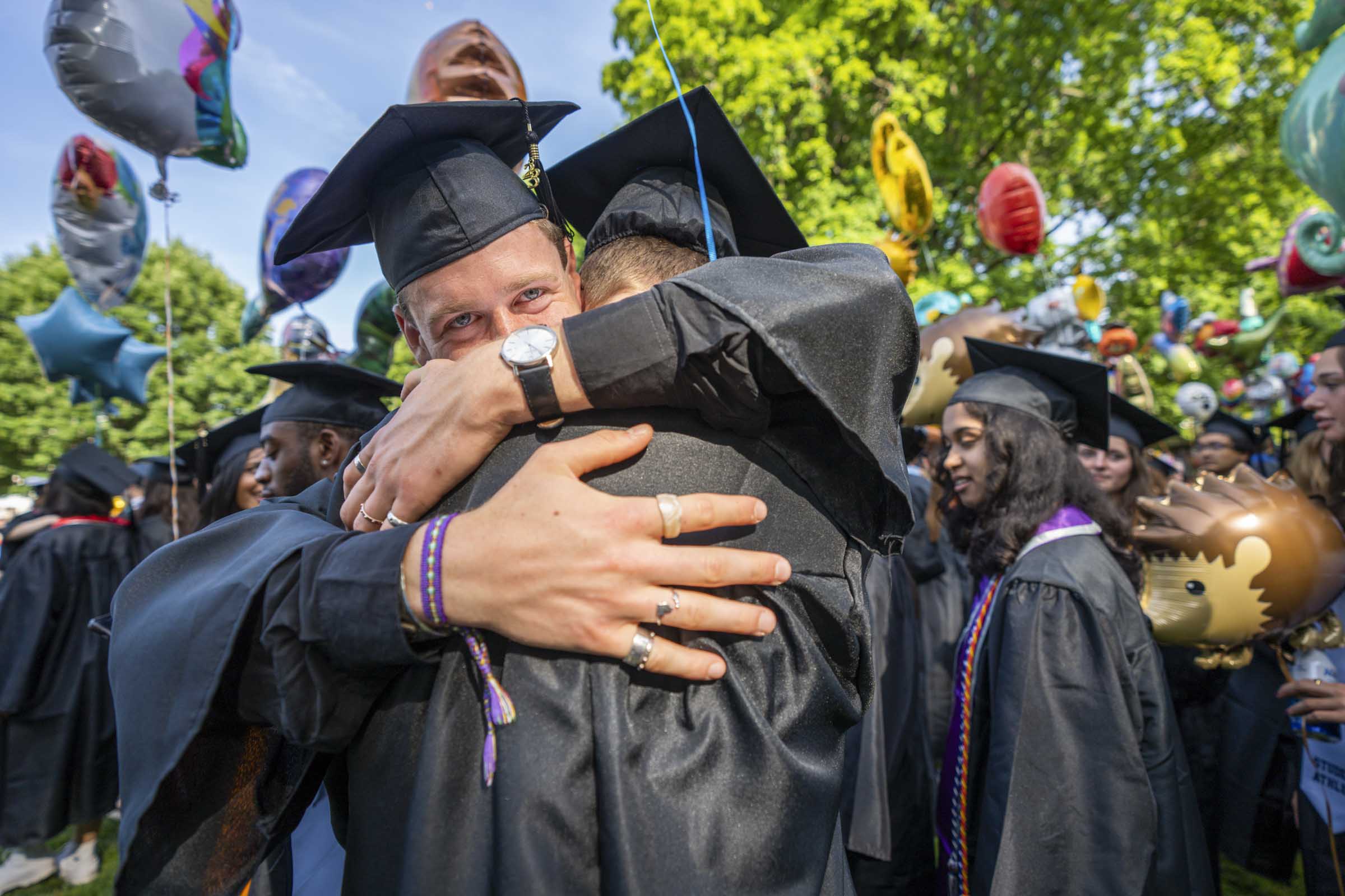 Two soon to be A&S graduates hug as they process down the Lawn