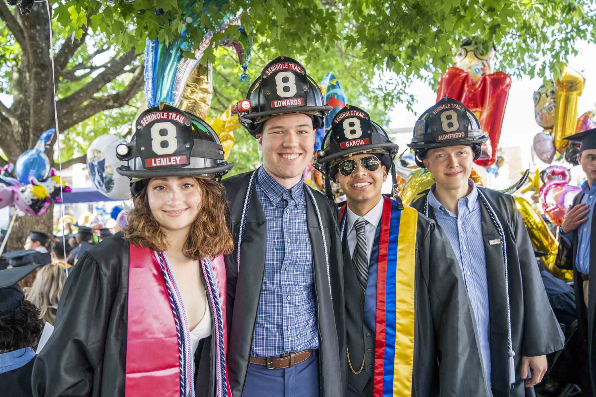 A group of four soon to be A&S graduates with fireperson hats