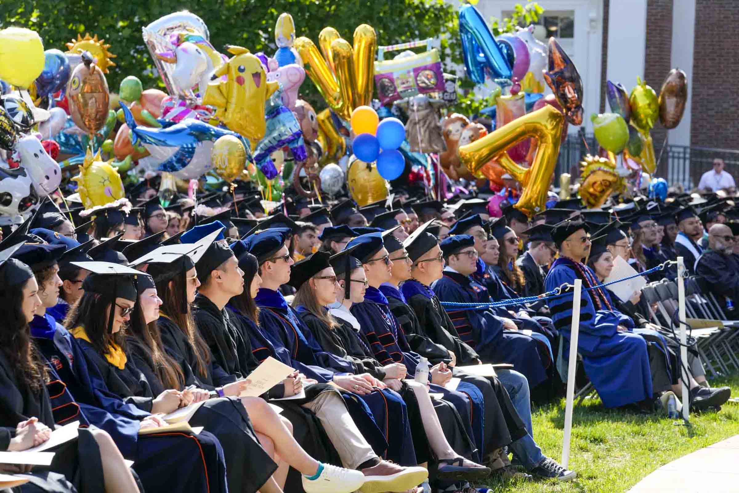 A happy group of soon to be A&S graduates with balloons sitting waiting for the ceremony to begin