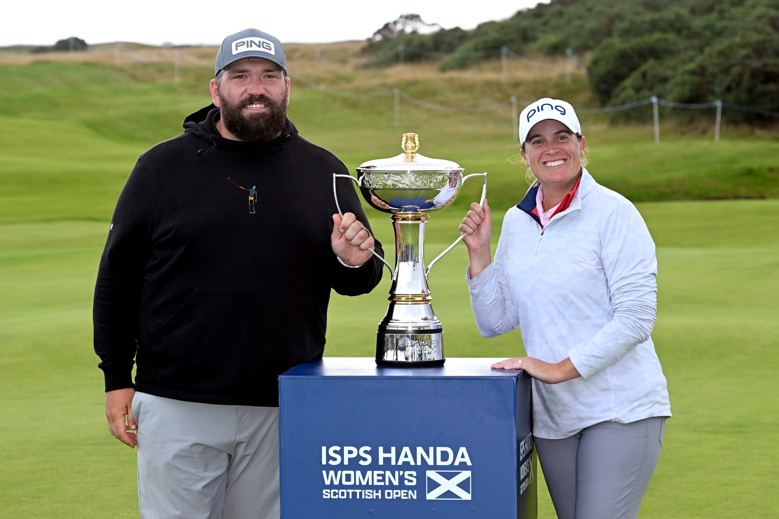 A portrait of UVA alumni John Pond and Lauren Coughlin, celebrating with their medals after winning the ISPS Handa Women’s Scottish Open.