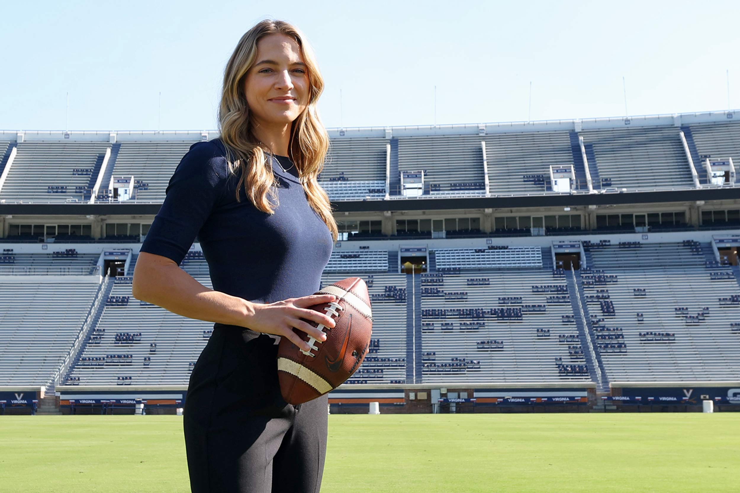 UVA alumna and ACC Network reporter Dana Boyle holds football in Scott Stadium